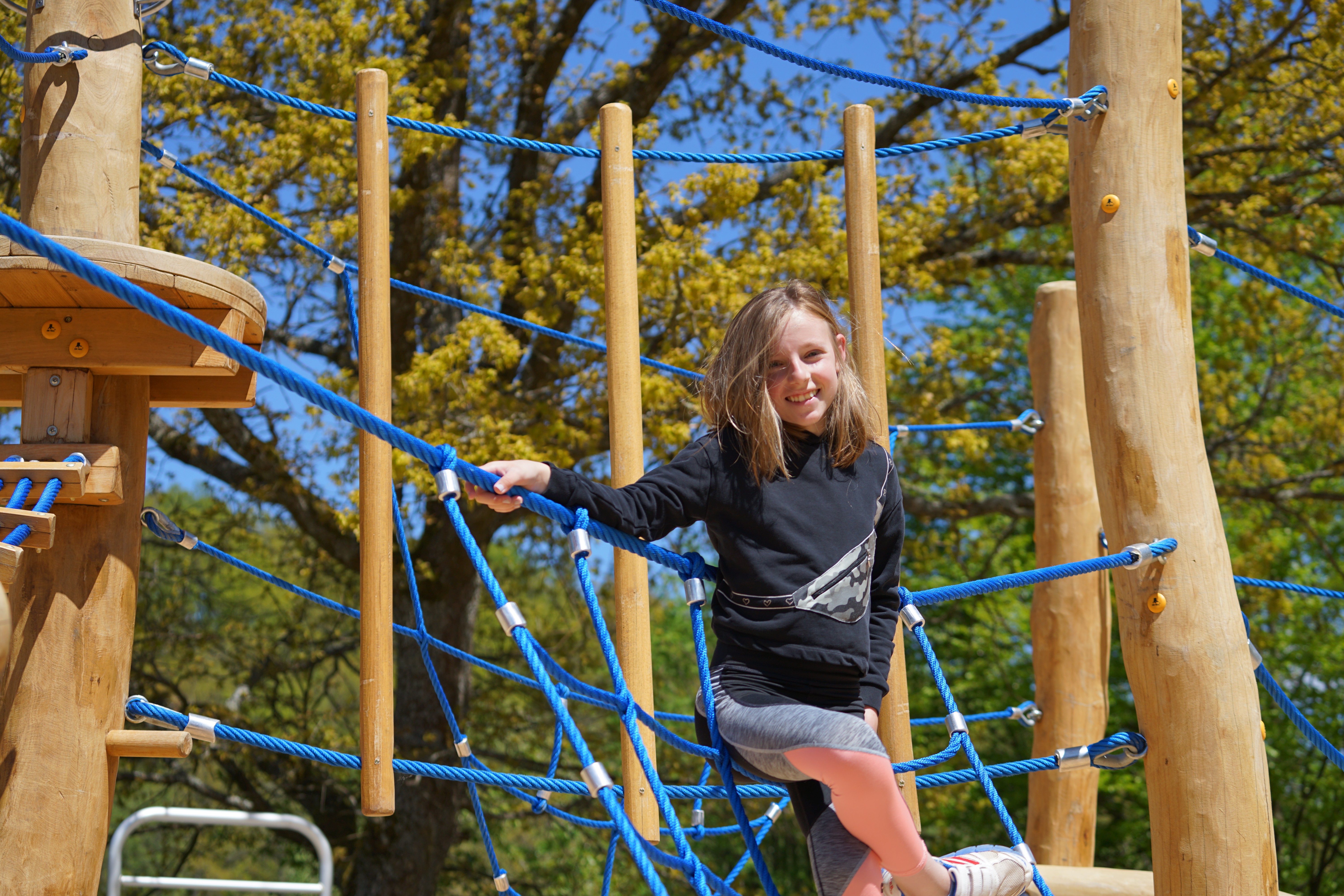 Mädchen auf einem Klettergerüst aus Holz