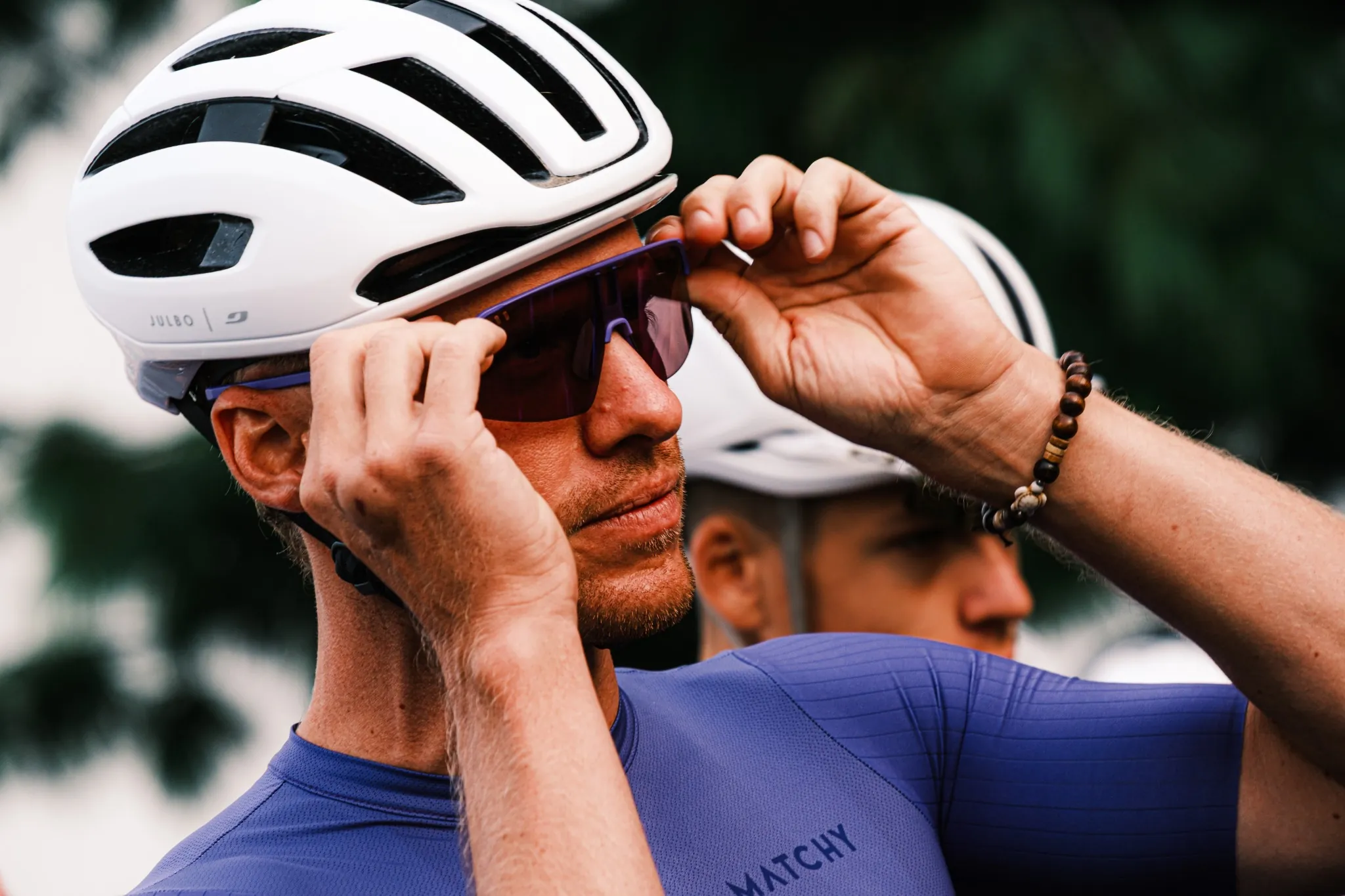 Cycliste ajustant ses lunettes Julbo avant la course, concentré avant le départ.