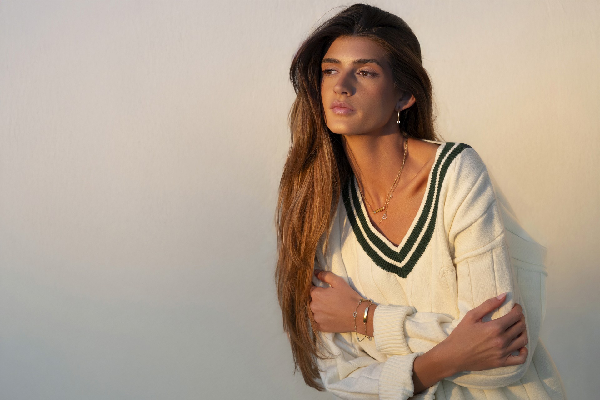 sunset photograph of model showcasing a necklace, bracelet, and earrings.