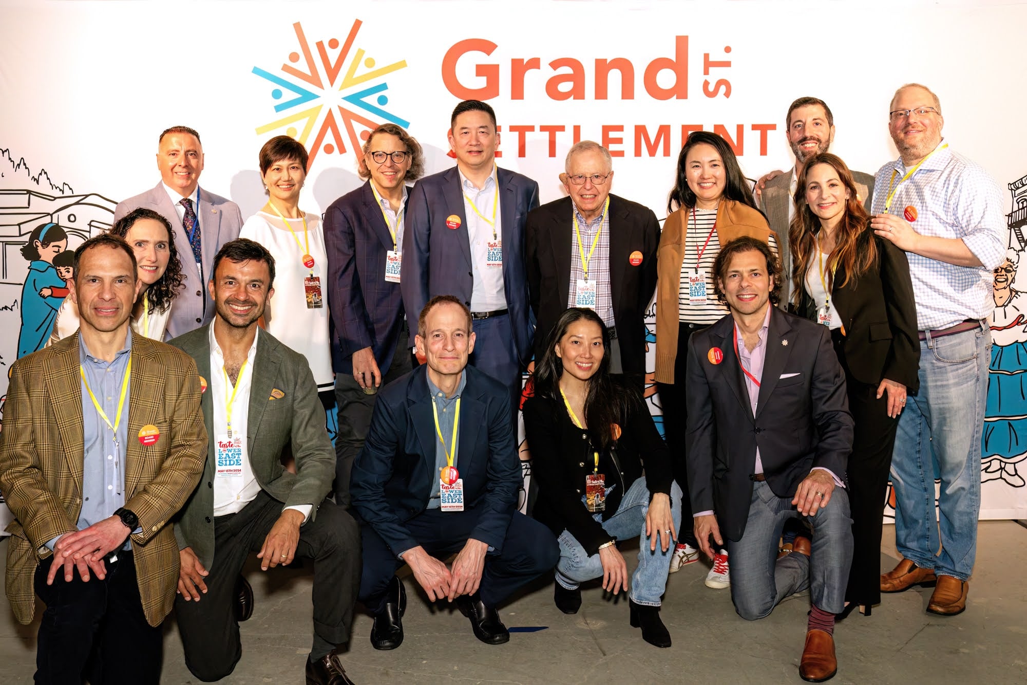 A picture of Grand St. Settlement's Board of Directors in front of an illustrated backdrop.