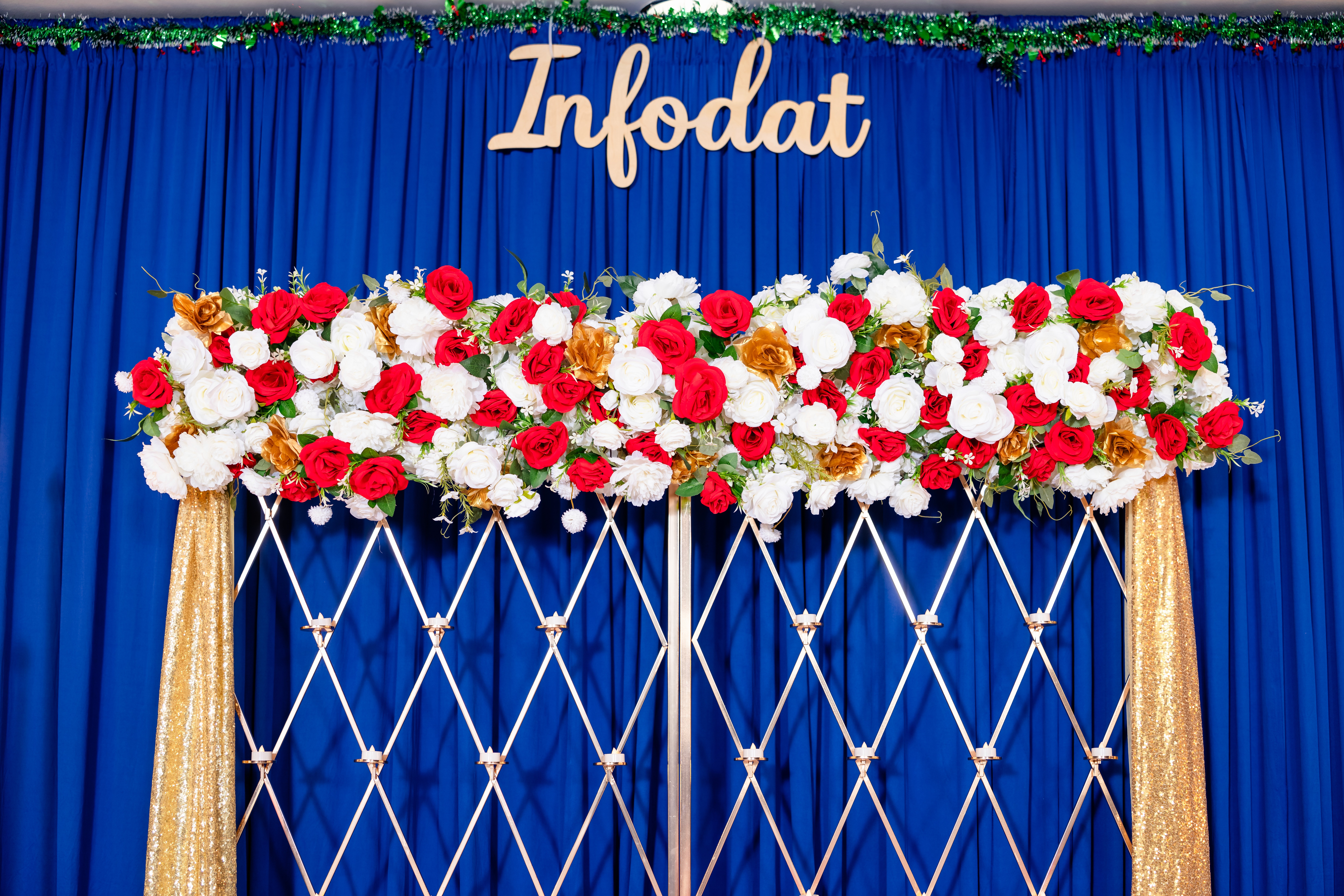 A bride in a lace wedding dress holds a vibrant bouquet of red and orange flowers.