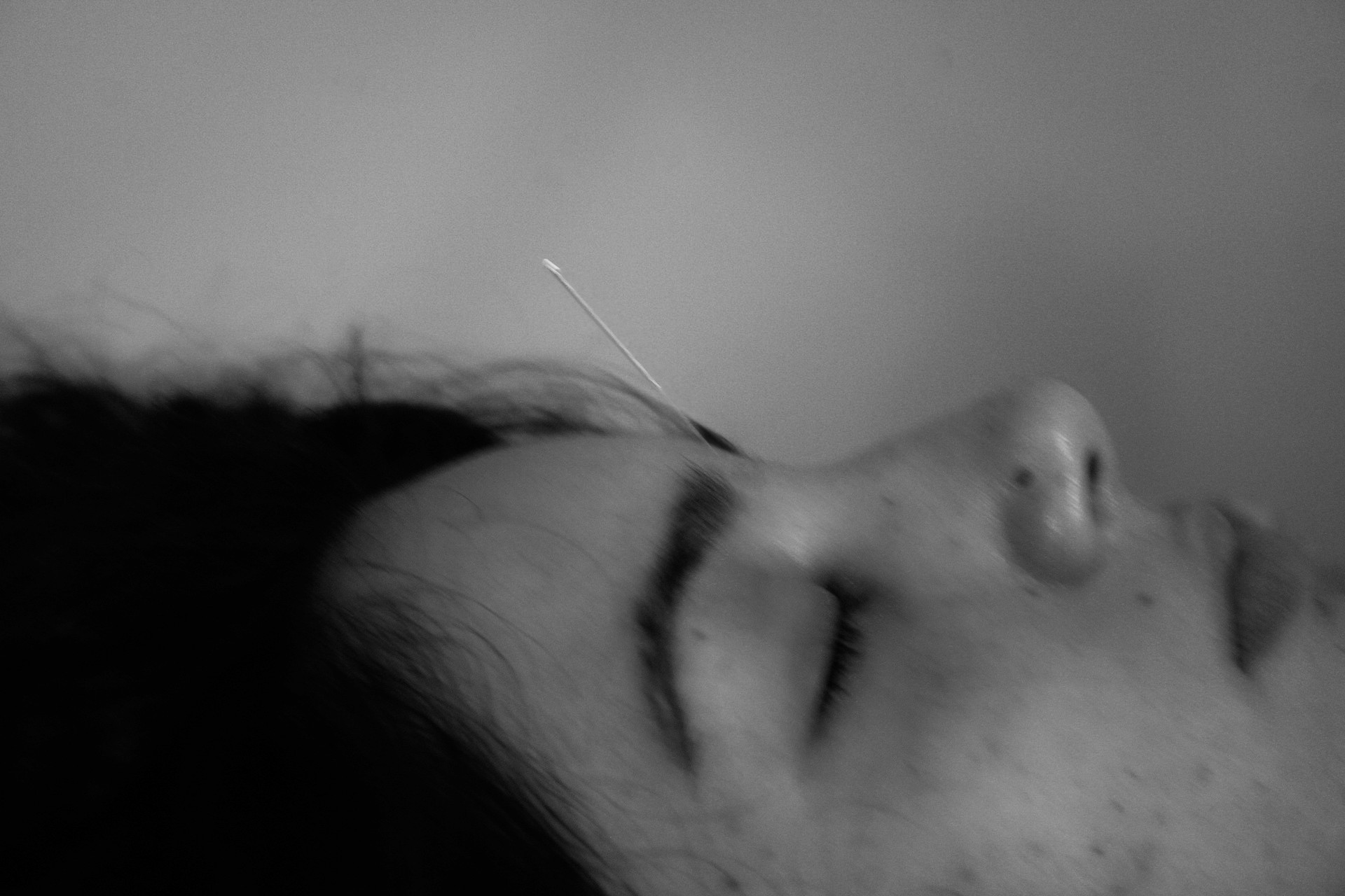 a needle sticking out of a womans forehead