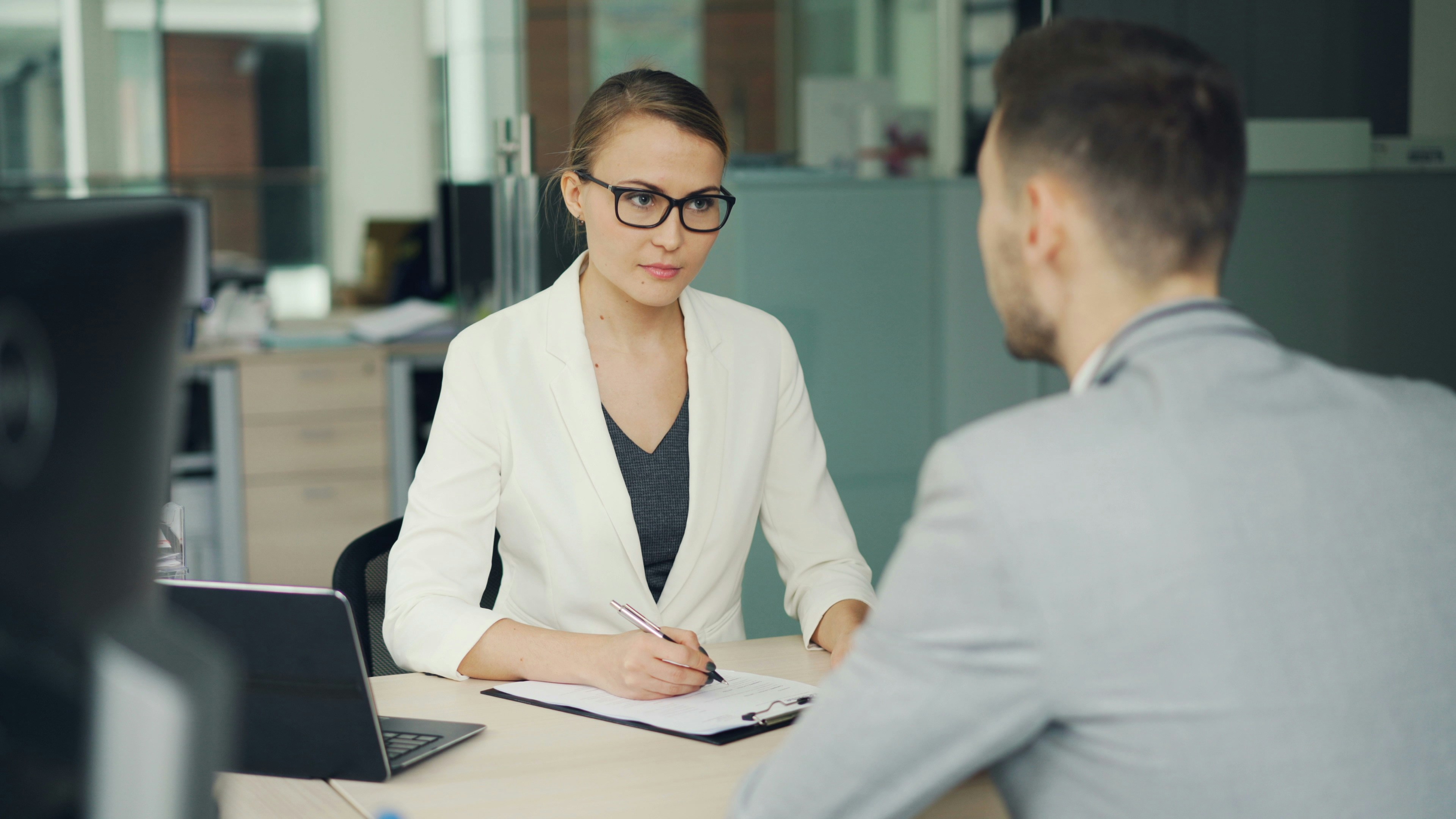 Hiring manager interviewing a job candidate in an office setting