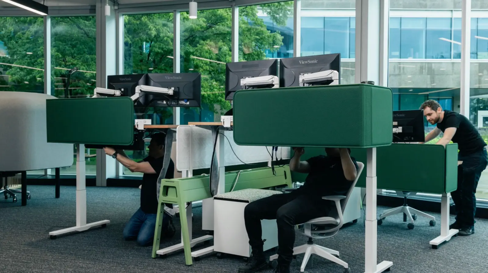 Modern office workspace with technicians setting up computer workstations and IT equipment, showcasing professional managed IT services