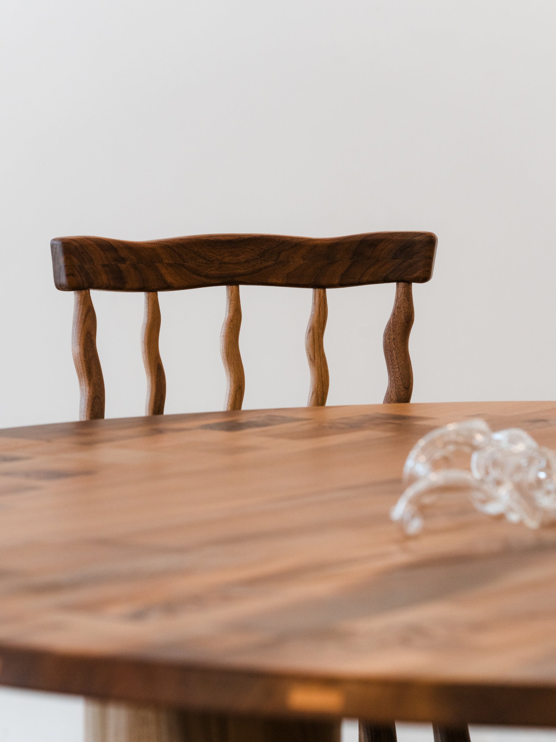 Backrest of walnut Windsor dining chair behind table