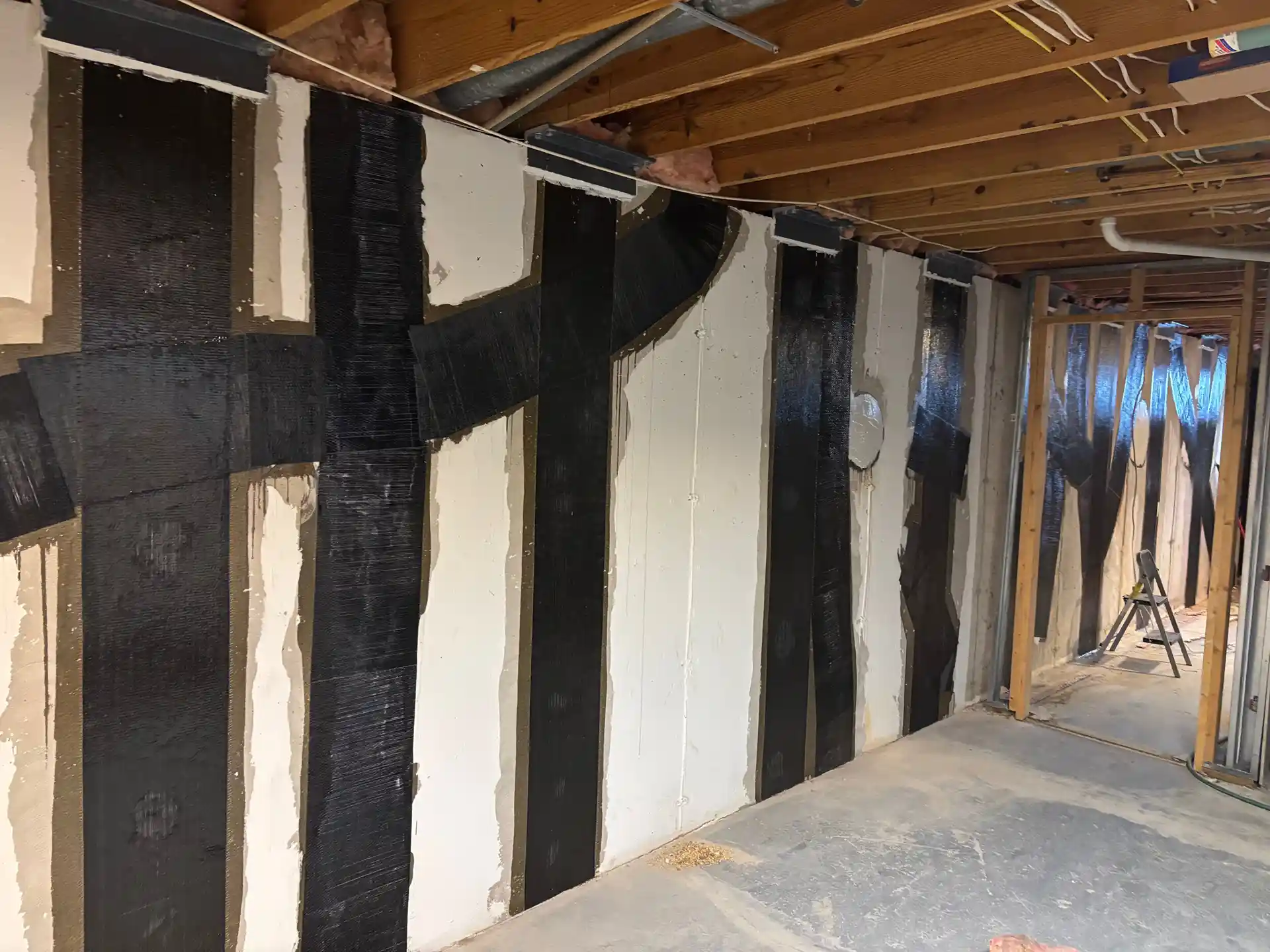 Mur de sous-sol avec bandes de fibre de carbone Fib-R-Wall sur un mur intérieur de sous-sol