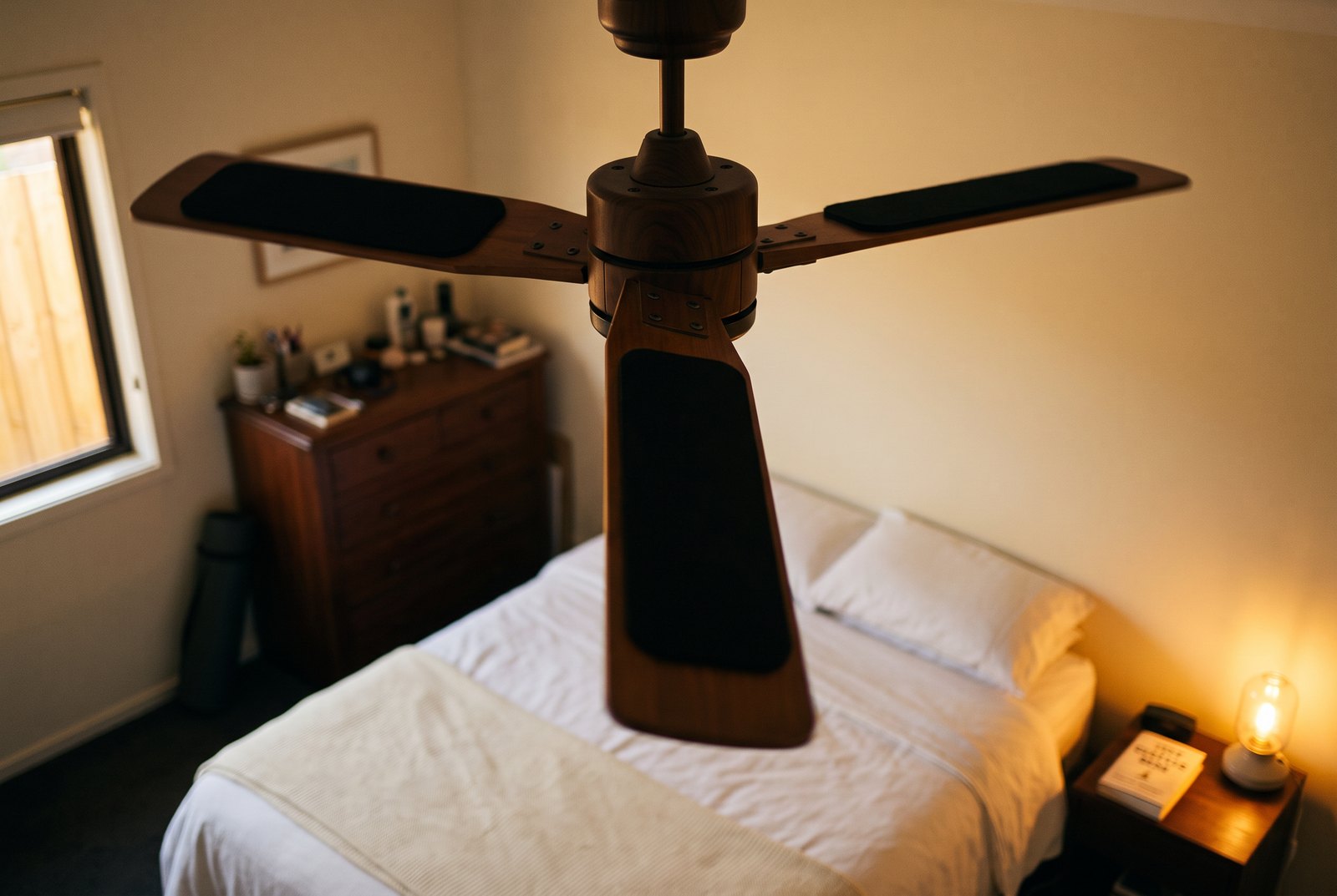 A ceiling fan with matte black Barnakl pads lying flat on top of the blades.
