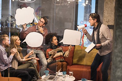 Mann schreit Team mit Megafon an