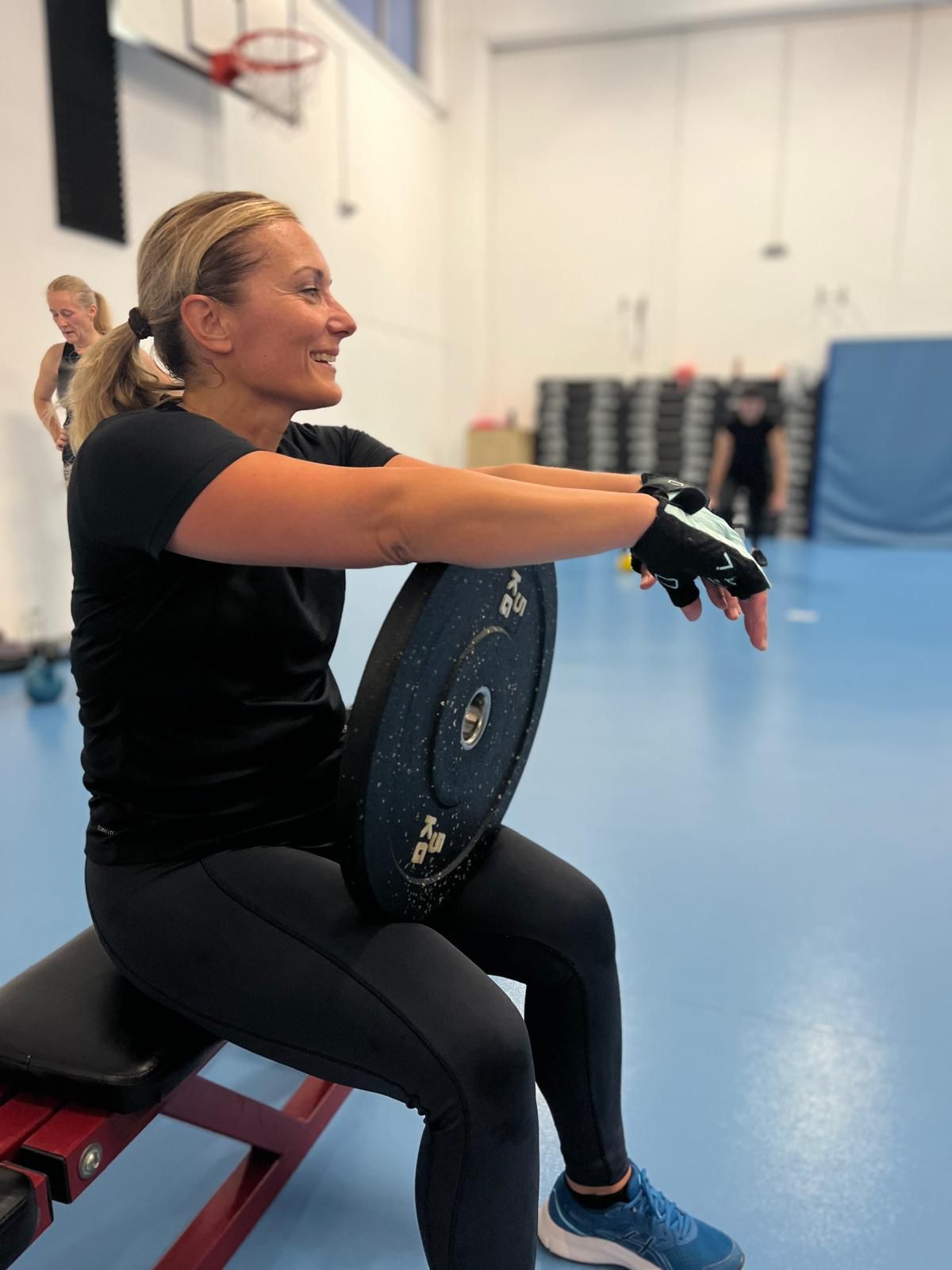 Žene izvode vježbe s utezima tijekom grupnog fitness treninga u dvorani.