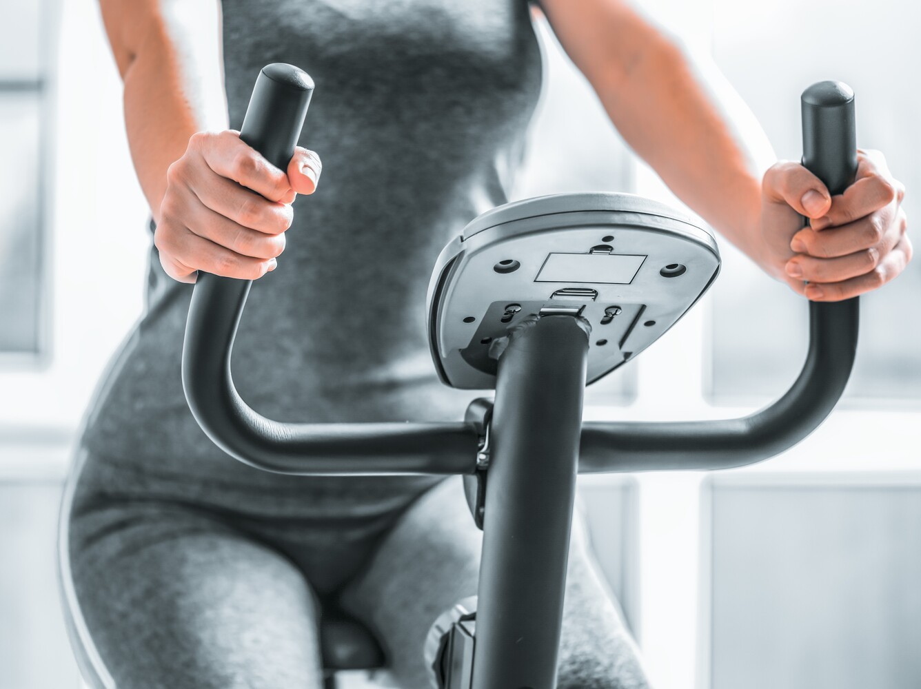 woman doing a Peloton-style stationary bike and weight loss routine