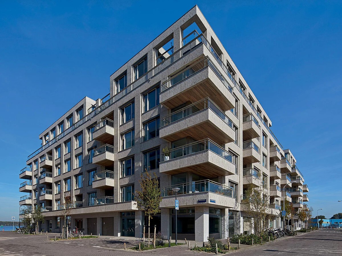 Modern appartementencomplex met balkons op een zonnige dag. Blauwe lucht.