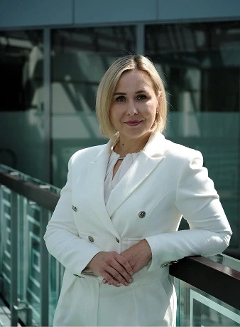 A person wearing a white suit standing outdoors.