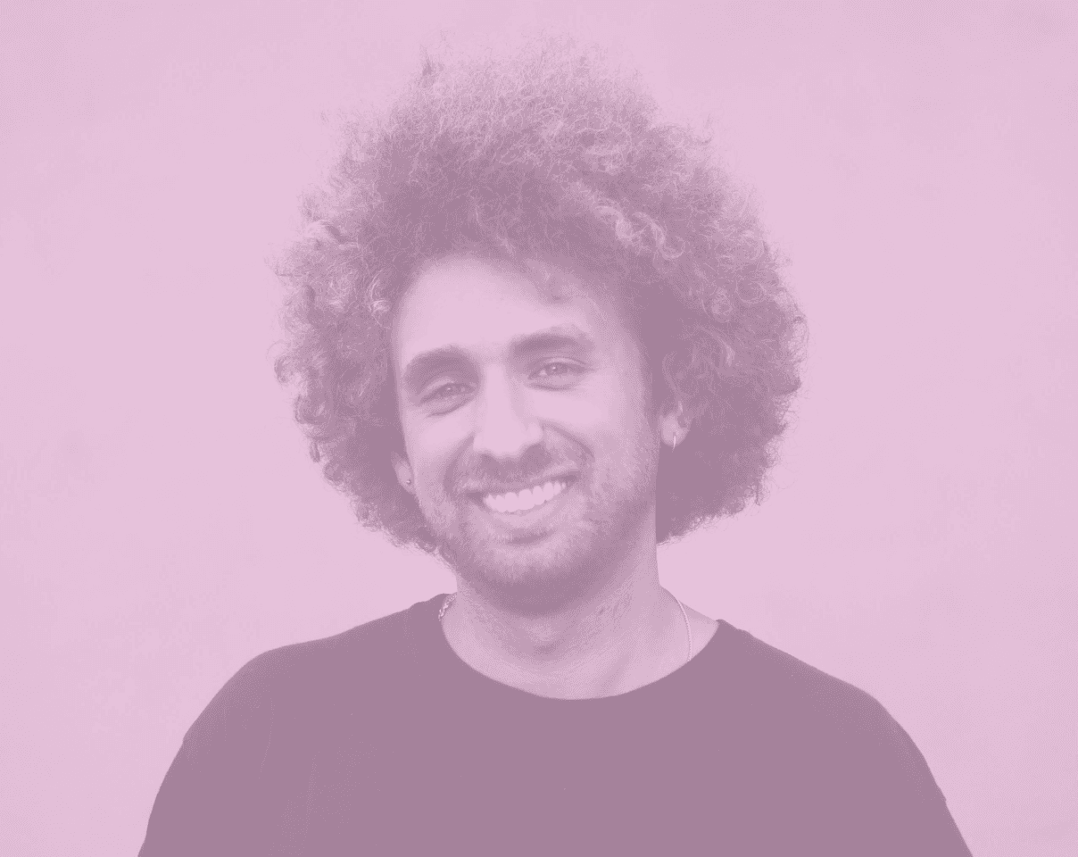 A close-up of a person wearing green-tinted glasses, with a serious expression and smooth skin.