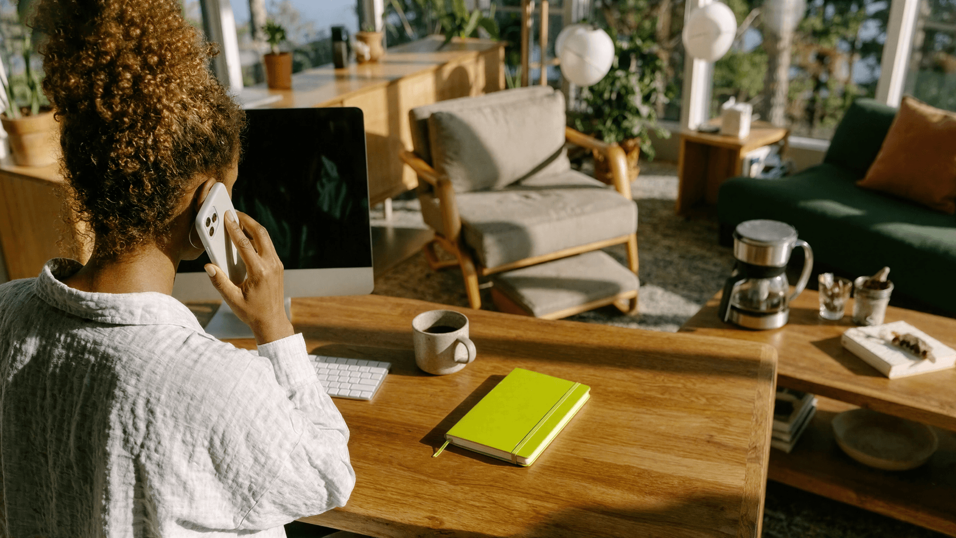 Profissional de saúde ao telefone em frente a um notebook, gerenciando a agenda da clínica com o apoio das soluções da Tivita.
