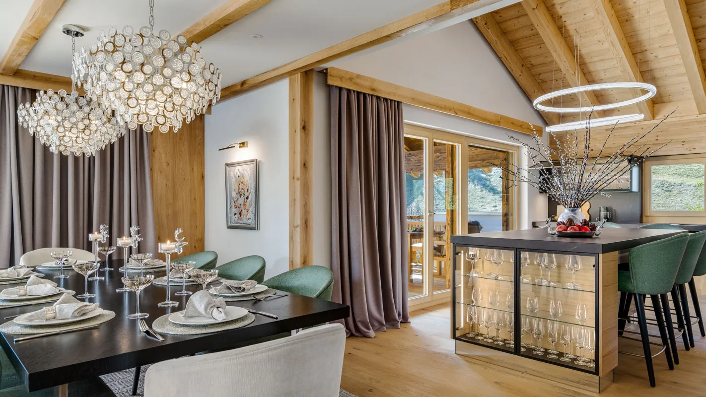 Silvretta Klosters dining area with crystal chandeliers, alpine wood beams, and a bar island with glass-front display