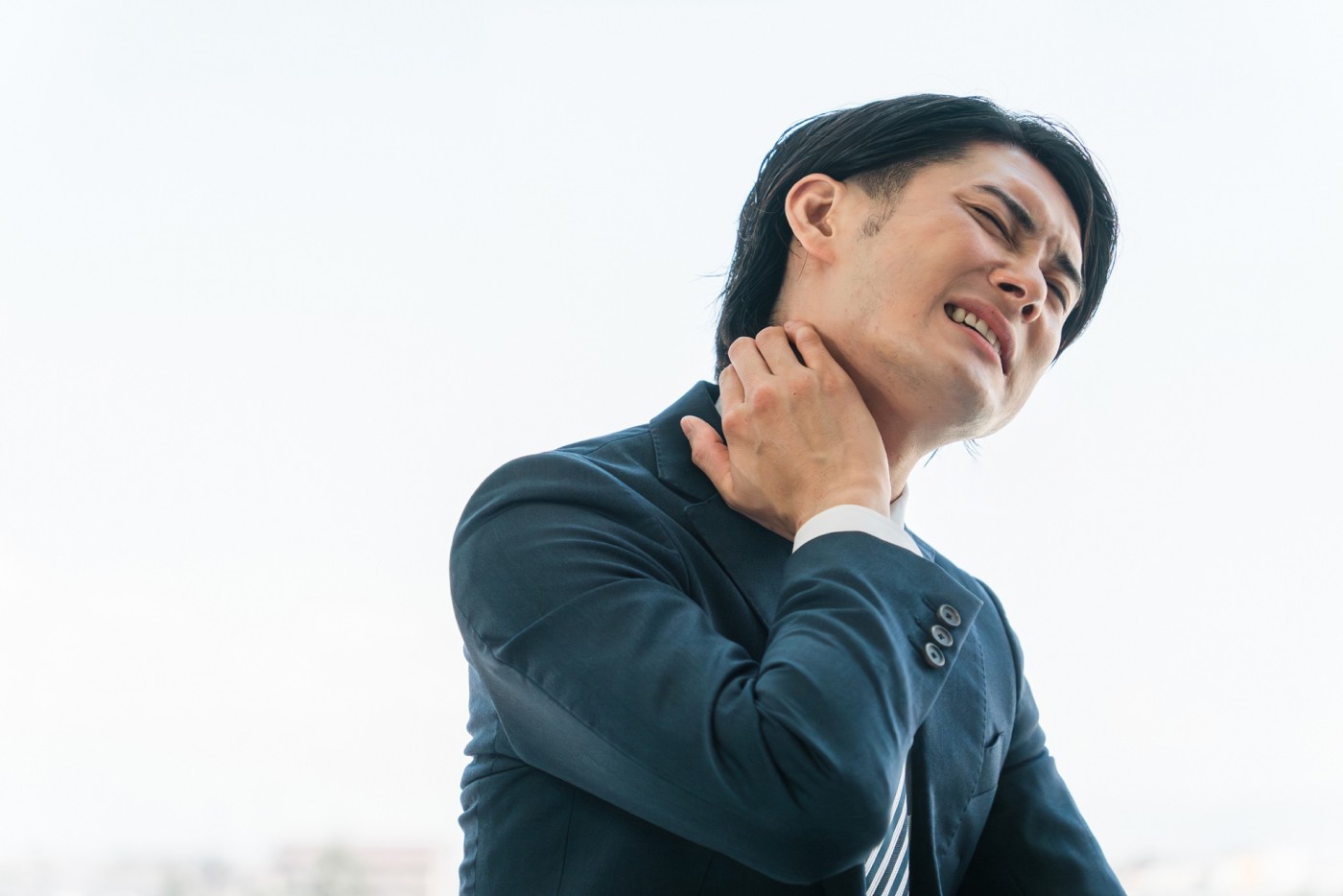 首を抑えて苦しそうにする男性