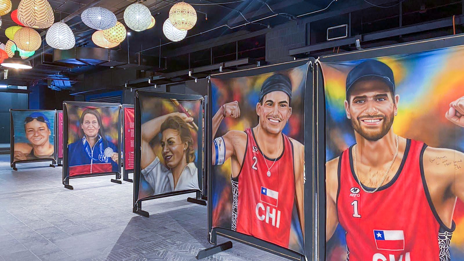 Activación de marca Score Energy Drink. Grupo de personas con latas de Score Energy Drink frente a la pintura de Eliseo Salazar en la exposición Leyendas del Deporte USACH.