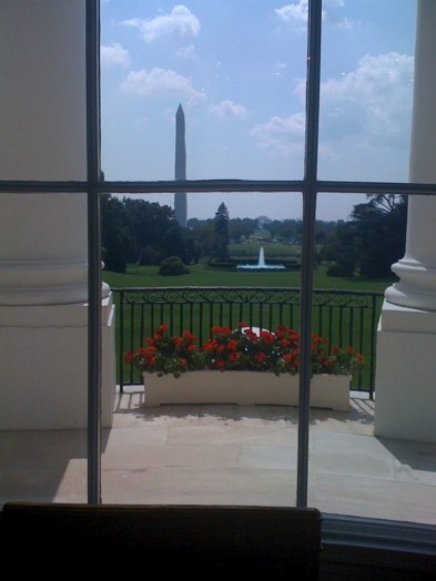a view through the window to Washington Monument on a sunny day with a partially cloudy sky