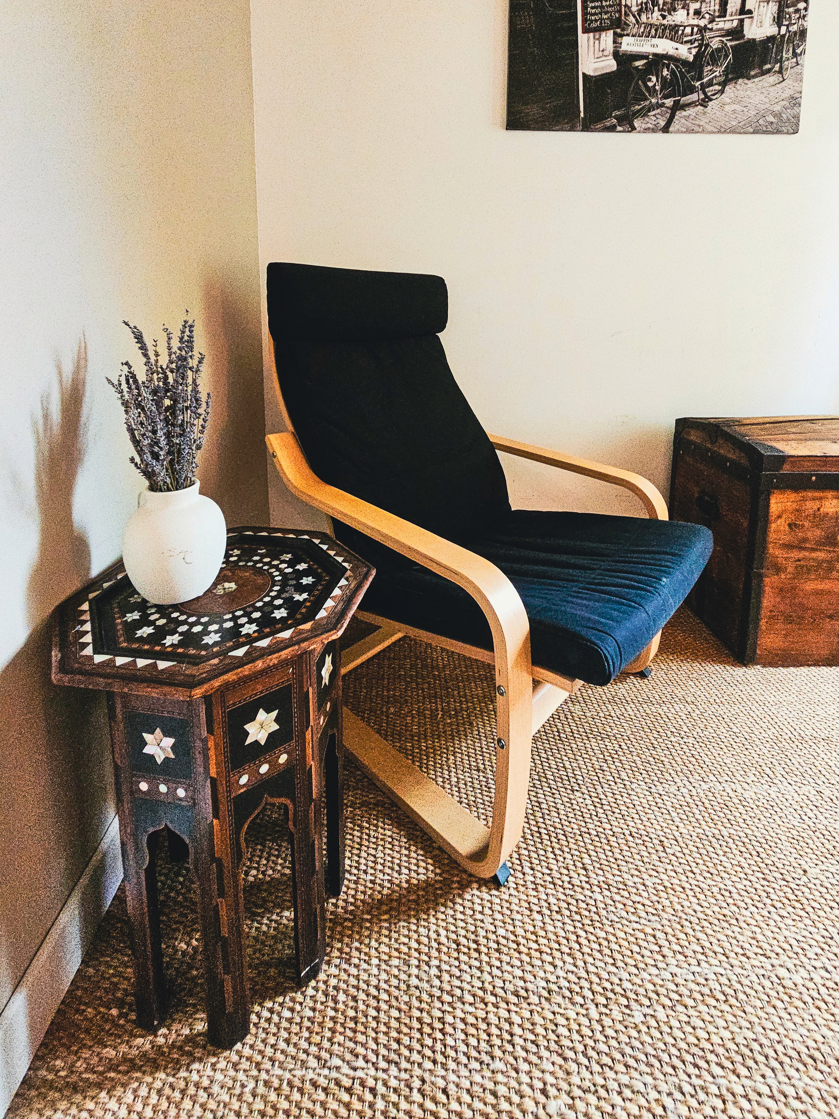 Chaise, table décorée, malle en bois, et lavande.