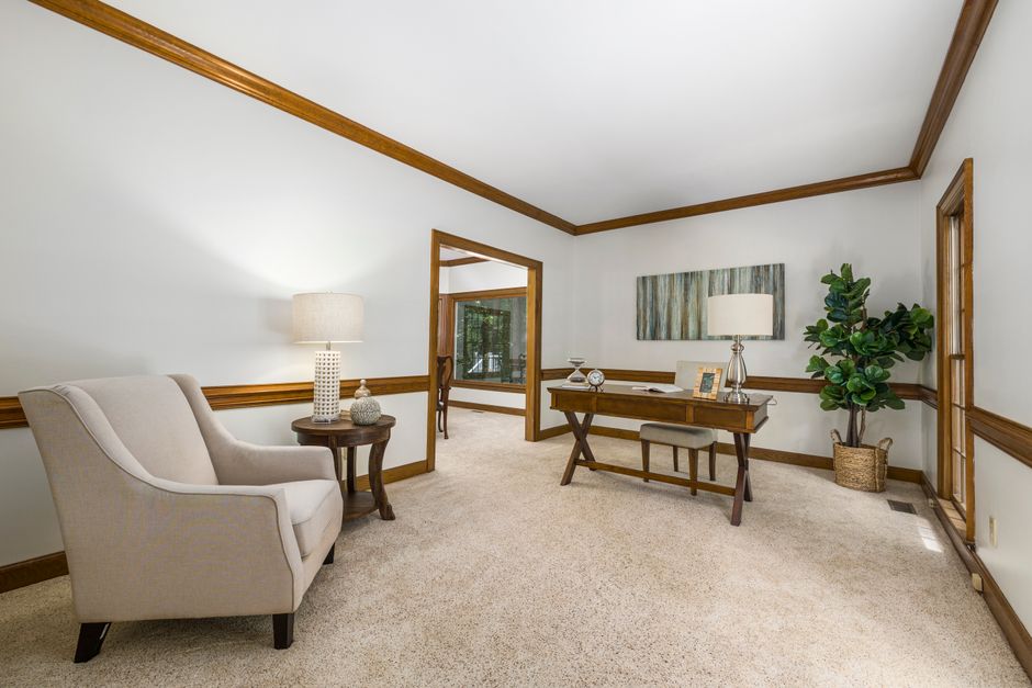 Spacious home office with elegant furnishings and natural decor for a stylish working environment.