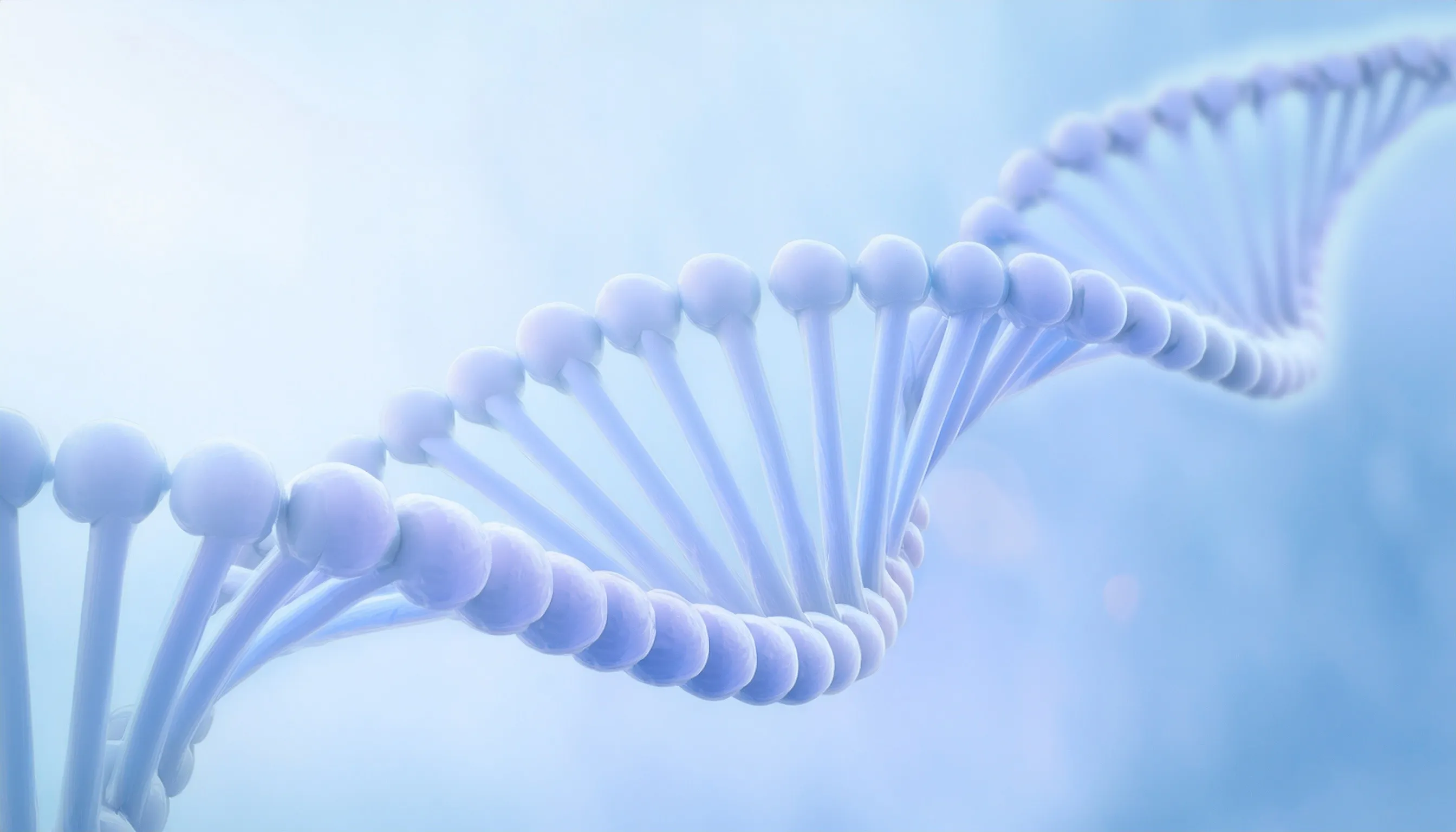 Man wearing an olive green jacket and black shirt, sitting and smiling in front of a light wooden background.
