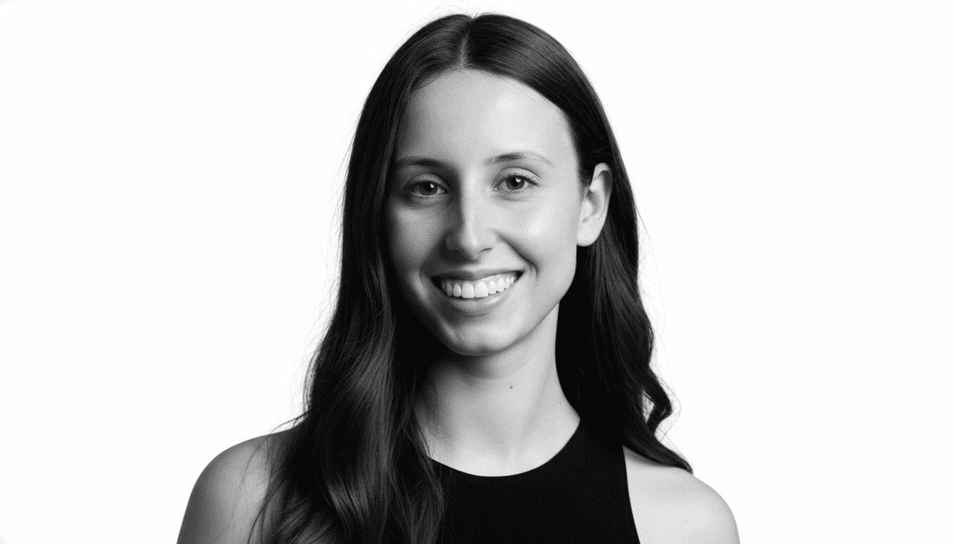 Portrait of a young man with short hair, wearing a dark t-shirt, against a plain background.