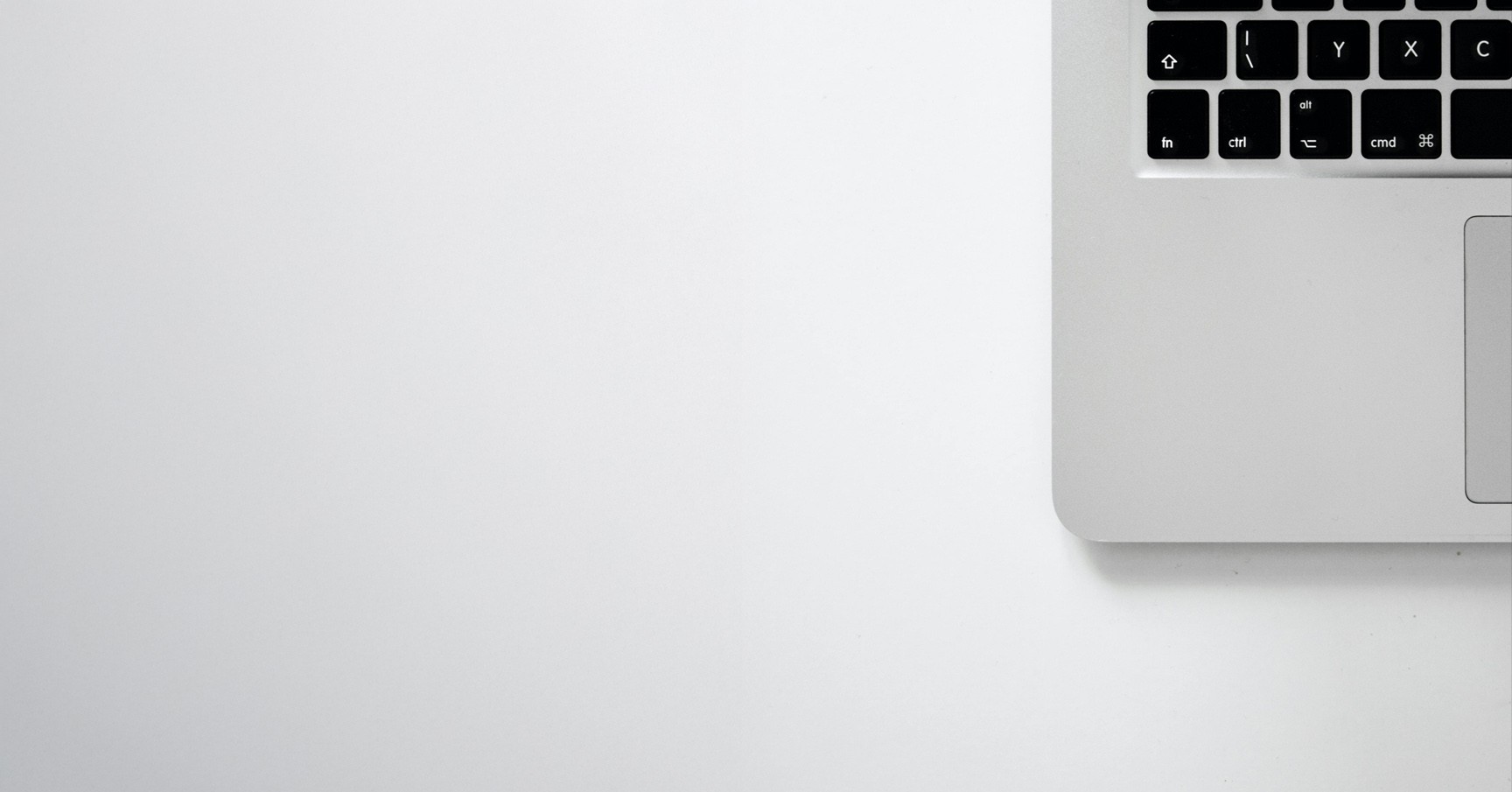 A close-up of a beige-colored laptop with a smooth, matte finish on a matching surface.