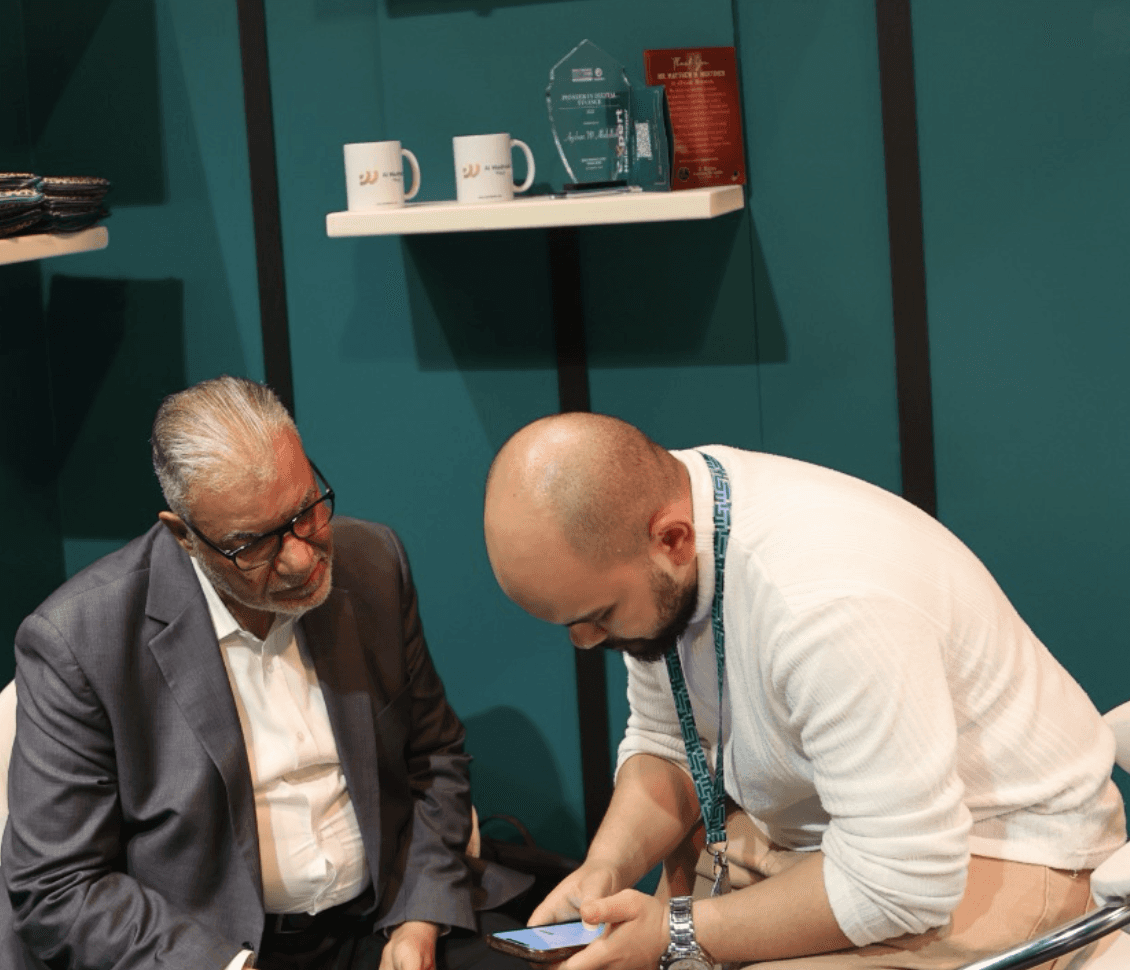 woman holding a phone and man looking at the phone. both are smiling