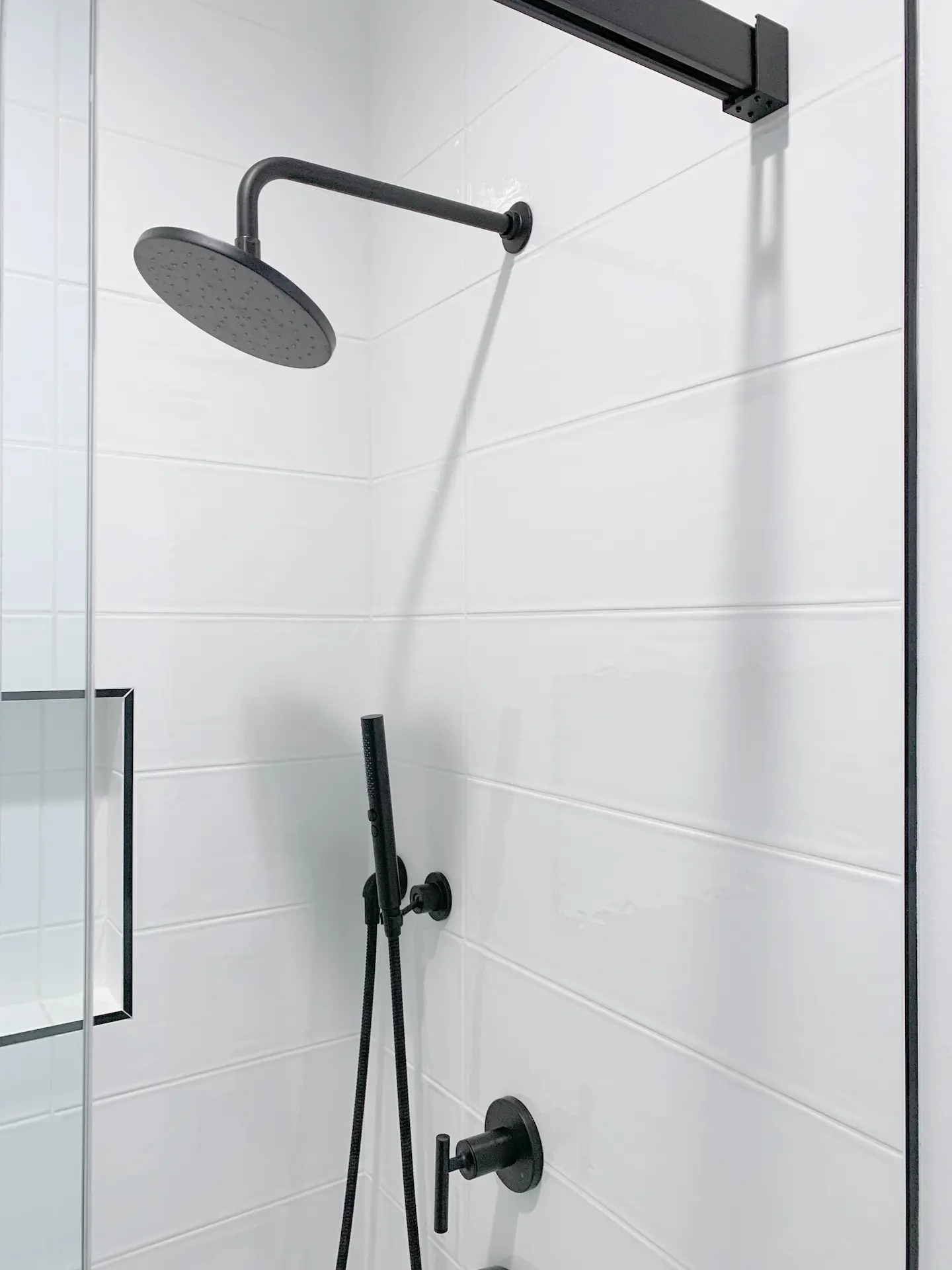 Closeup of the shower head in the kids' bathroom, a contemporary fixture that enhances the shower experience with its sleek design. Photo by Todd Huge.