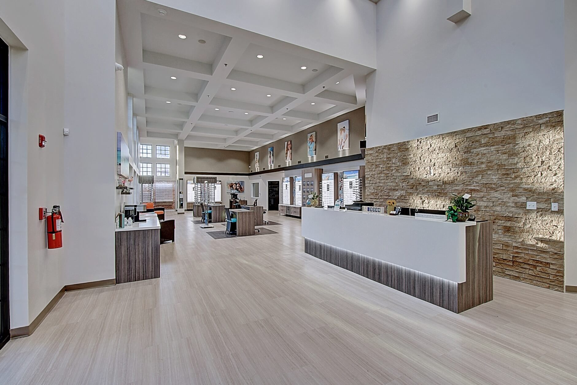 Modern interior of a bright, spacious lobby with a reception area, large windows, and sleek furnishings.