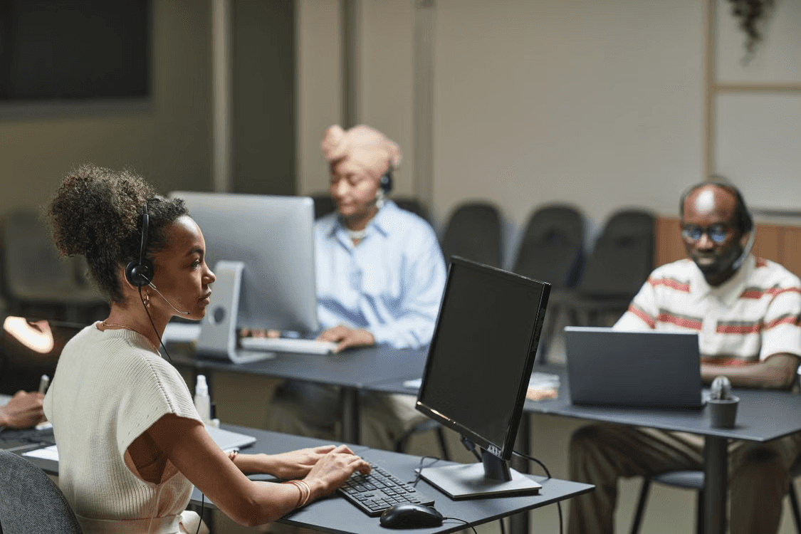 Two women wearing headsets in a bright office workspace