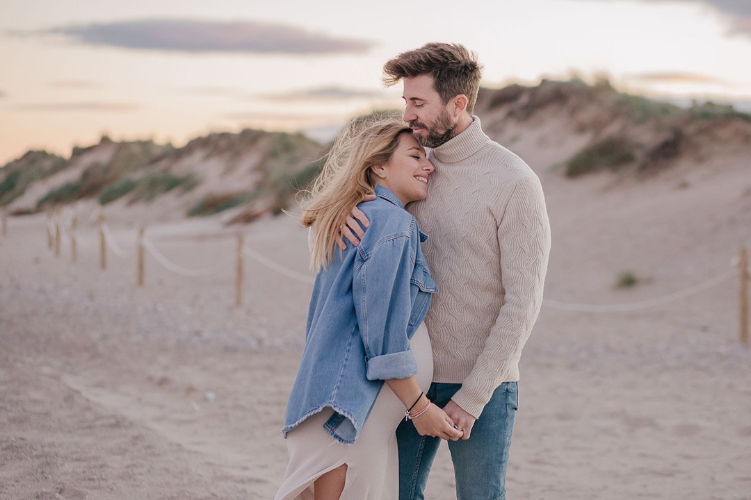 Chica embarazada junto a su pareja mirandose los dos con una sonrisa