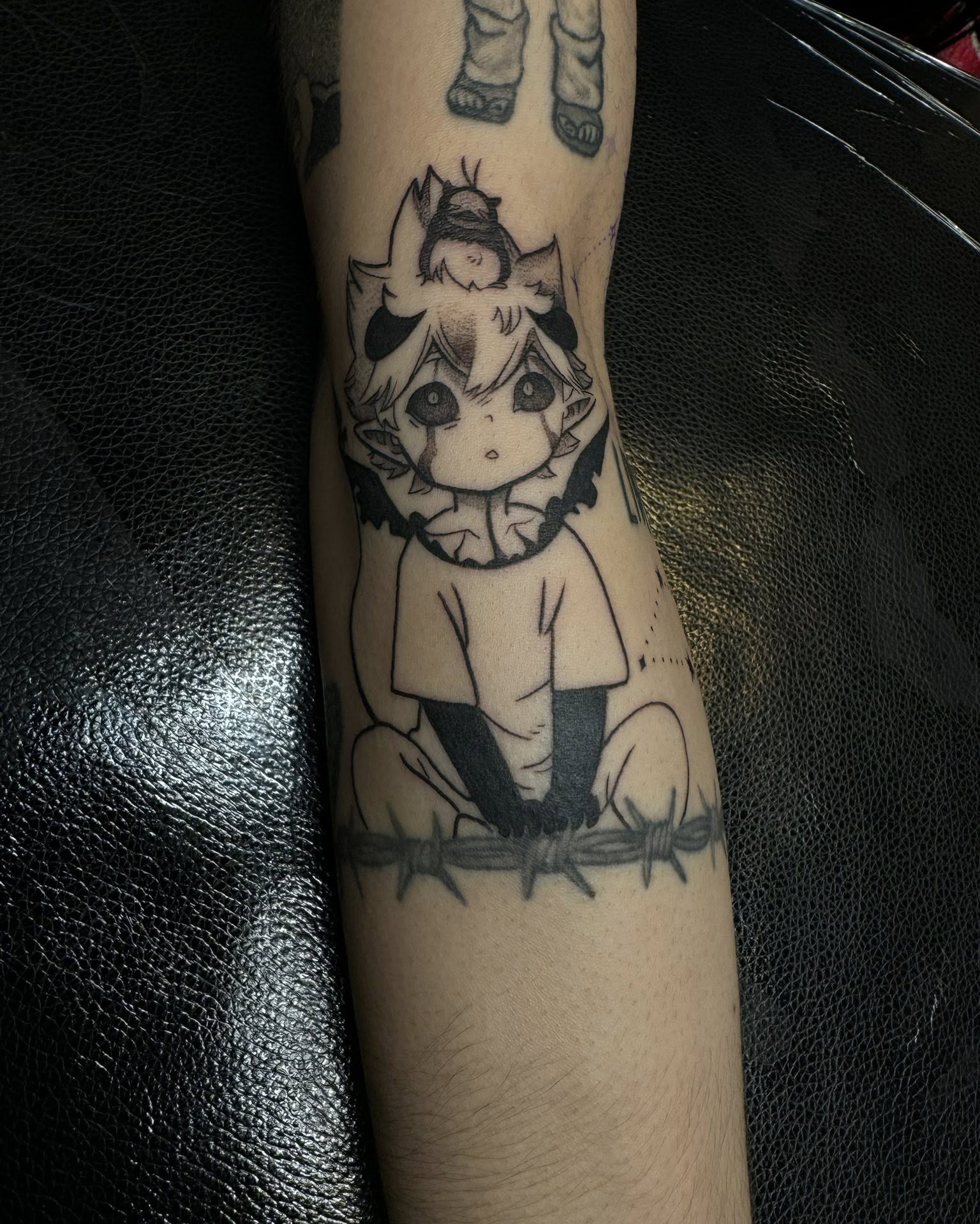 A forearm tattoo of Nezuko Kamado from Demon Slayer, depicted in a stylized anime art style. She is holding a sword.