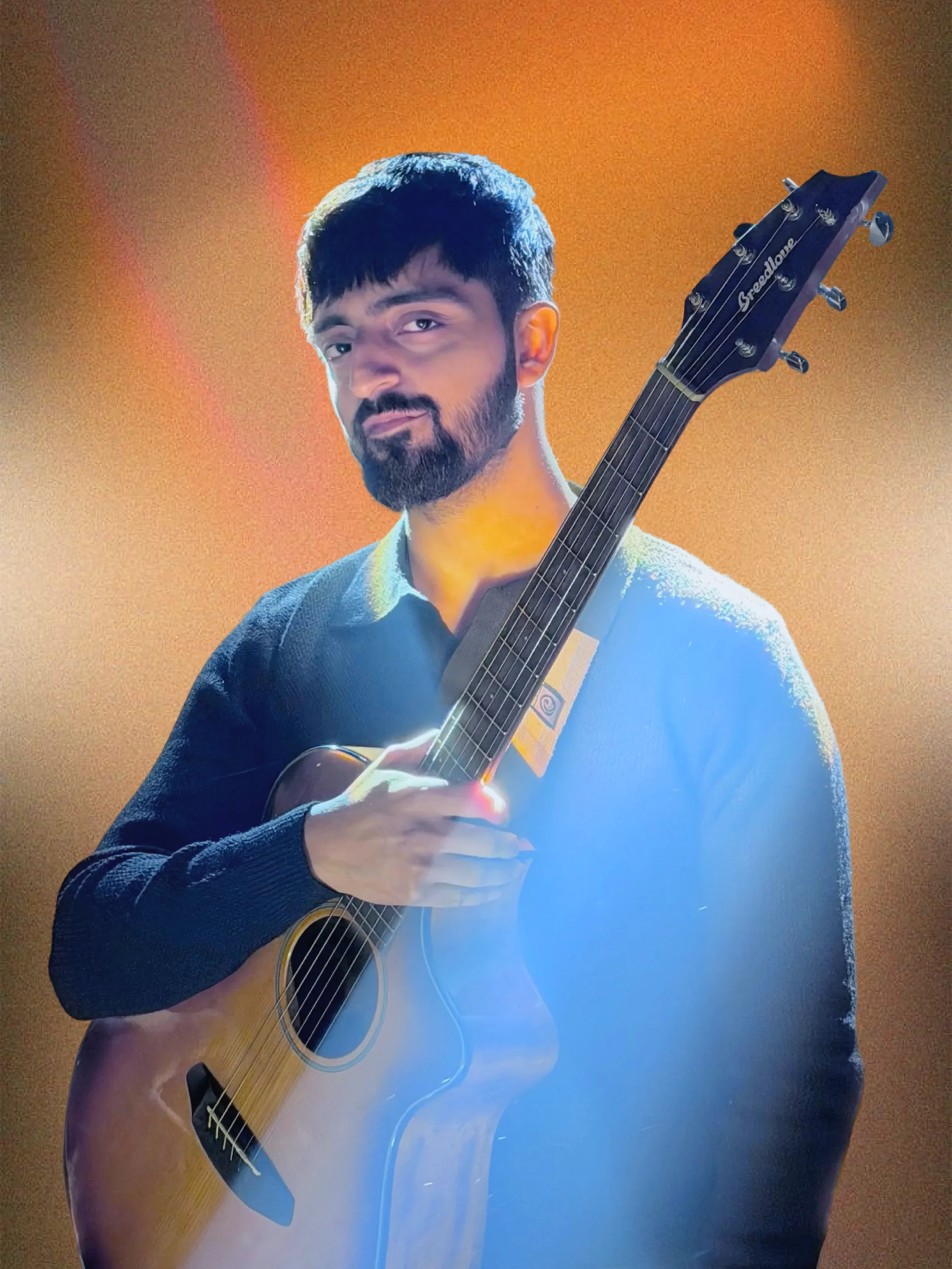 Singer standing with his guitar looking into the camera