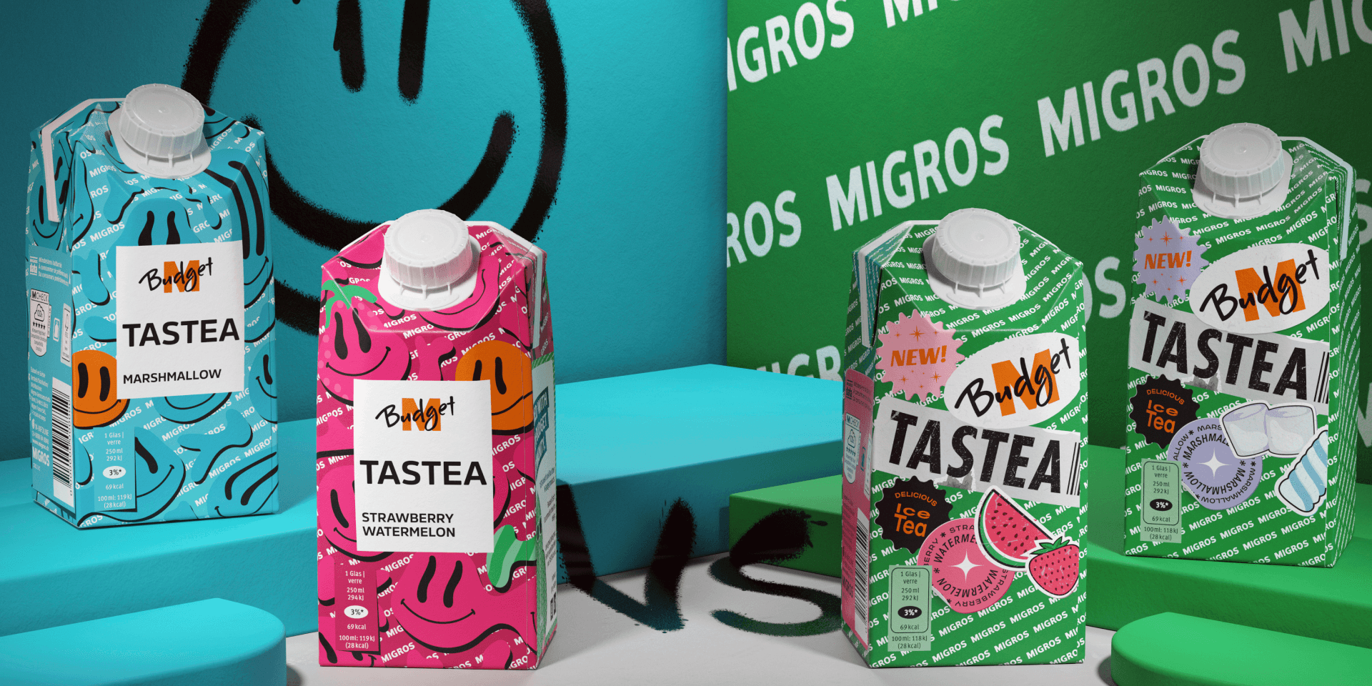 Markenwelt M-Budget Tastea – Tetra-Pak-Eistees in Sorten „Marshmallow" und „Strawberry Watermelon" in Türkis und Pink, vor Migros-Branding-Wand.