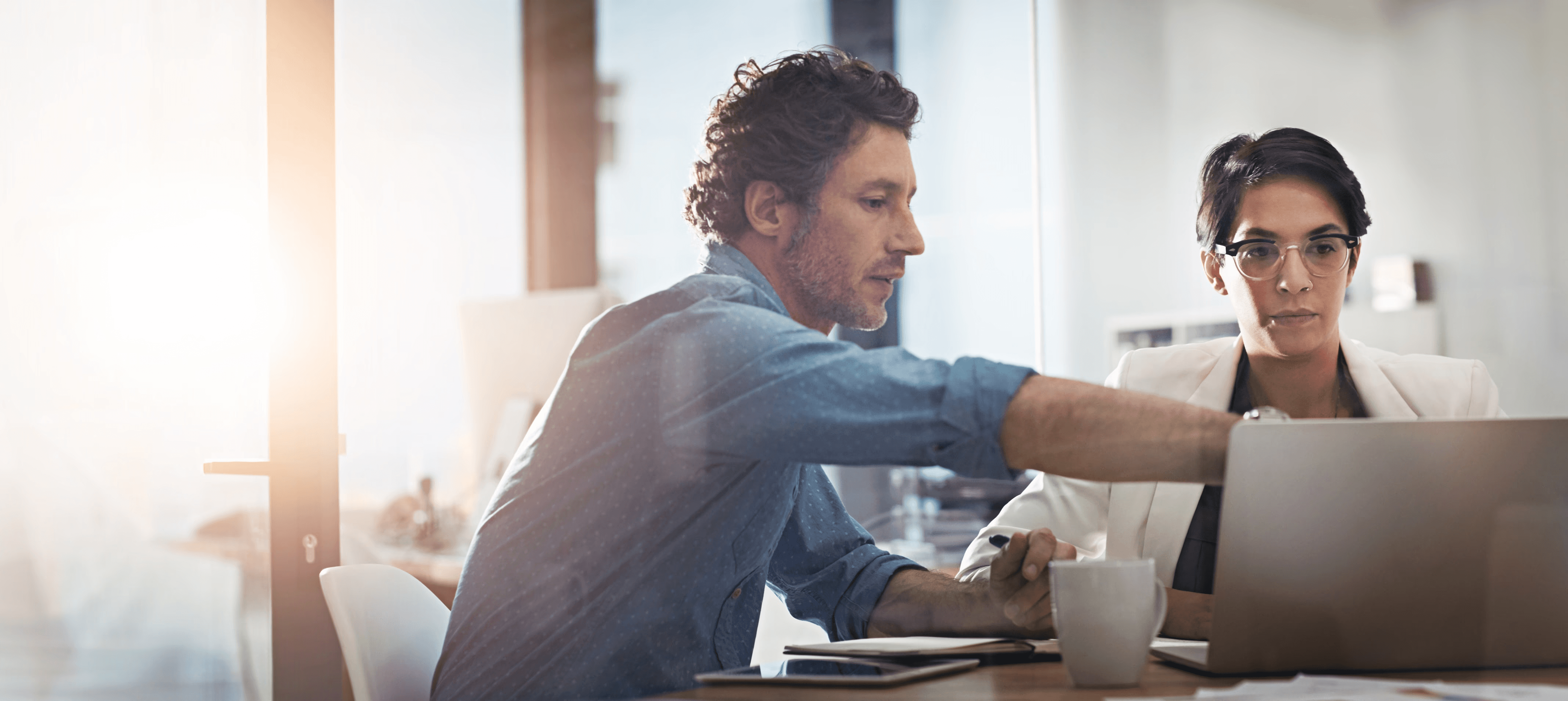 Ein Manager erklärt einem Auditor in einem Meeting die Praktiken des KI-Lebenszyklus und der Daten-Governance, und repräsentiert dabei die Prüfung von Kontrollmechanismen im KI-Lebenszyklus, Daten-Governance und Nachweisen über Beschaffung, Schulung, Einsatz und Überwachung gemäß ISO/IEC 42001.