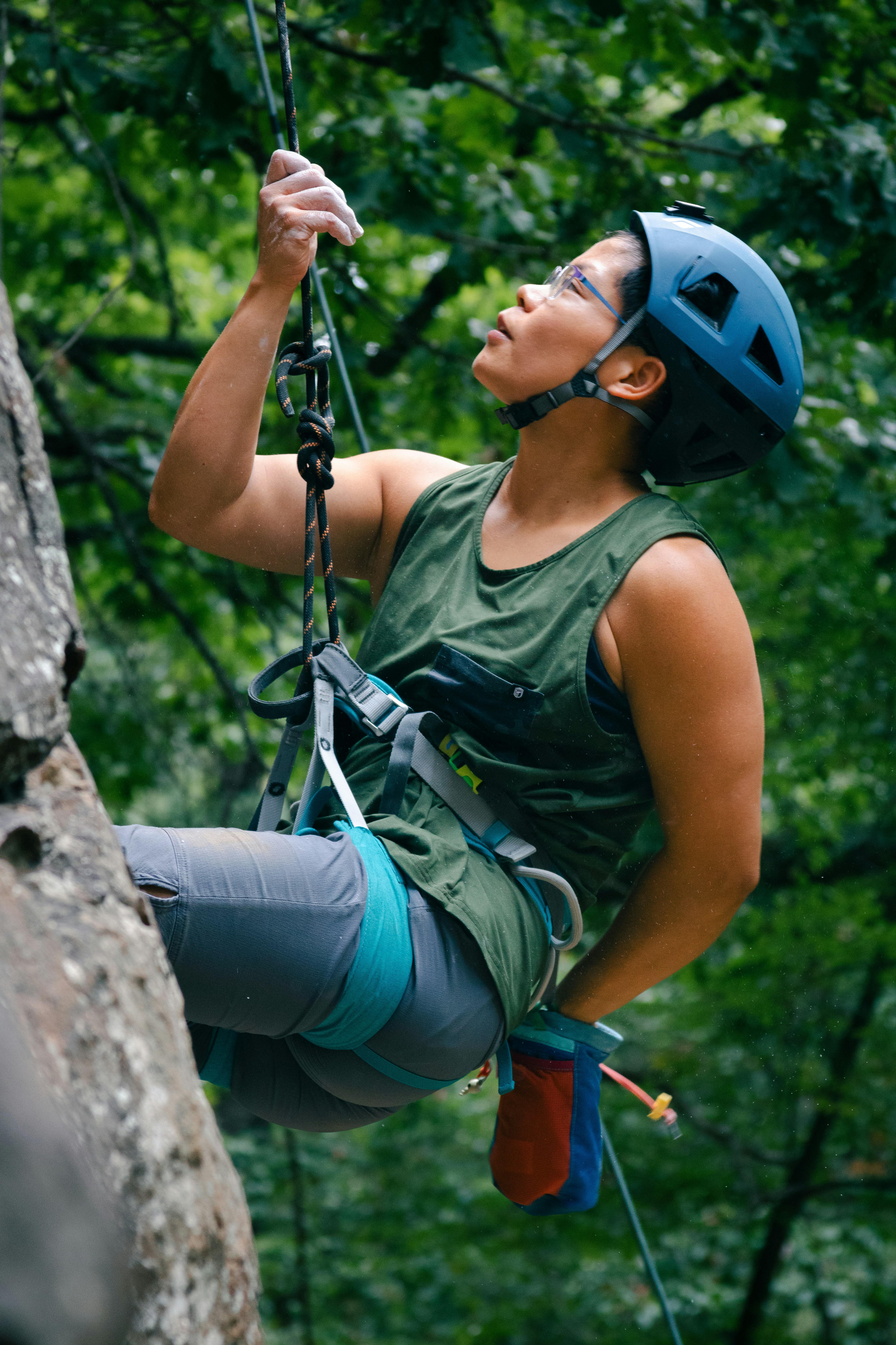 A woman climbing up the side of a tree