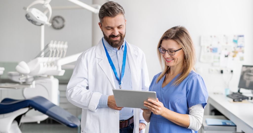 Dental professionals reviewing patient data on a tablet.