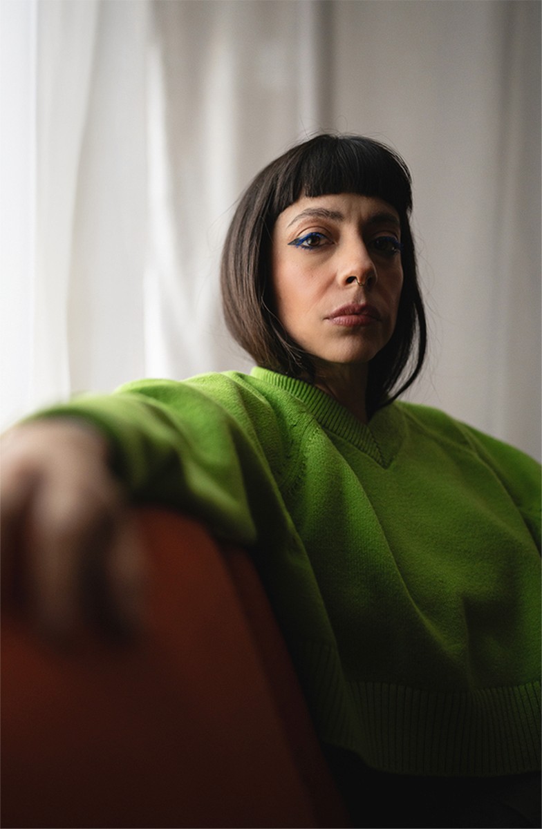 woman wearing a green sweater with studio lighting 