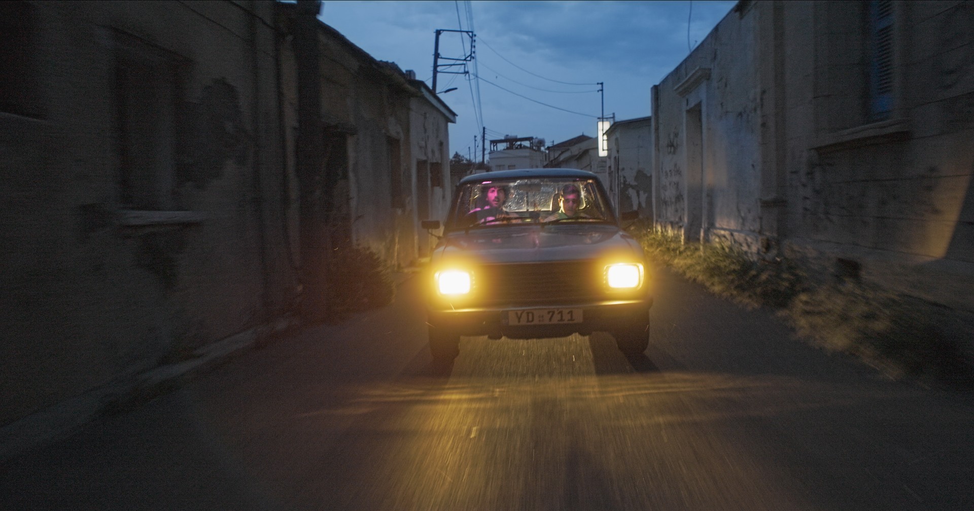 A singer raps Blue vintage car in the streets of Larnaca, at Cyprus for the filming of his music videoclip 