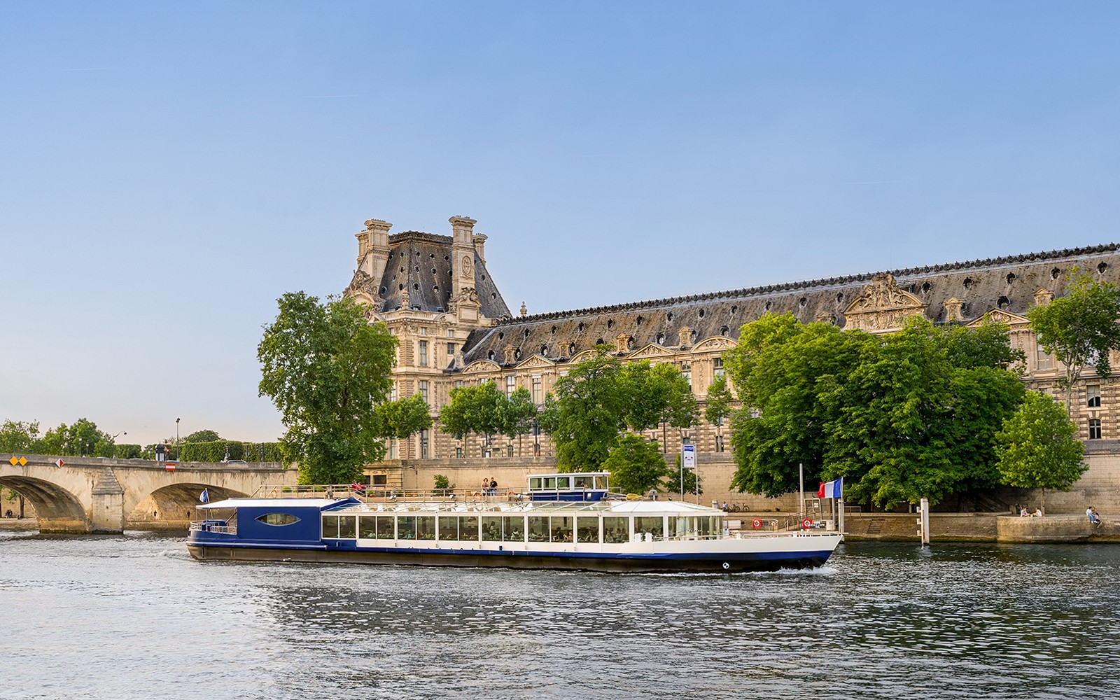 在塞纳河上进行晚宴巡游的游船经过巴黎卢浮宫。