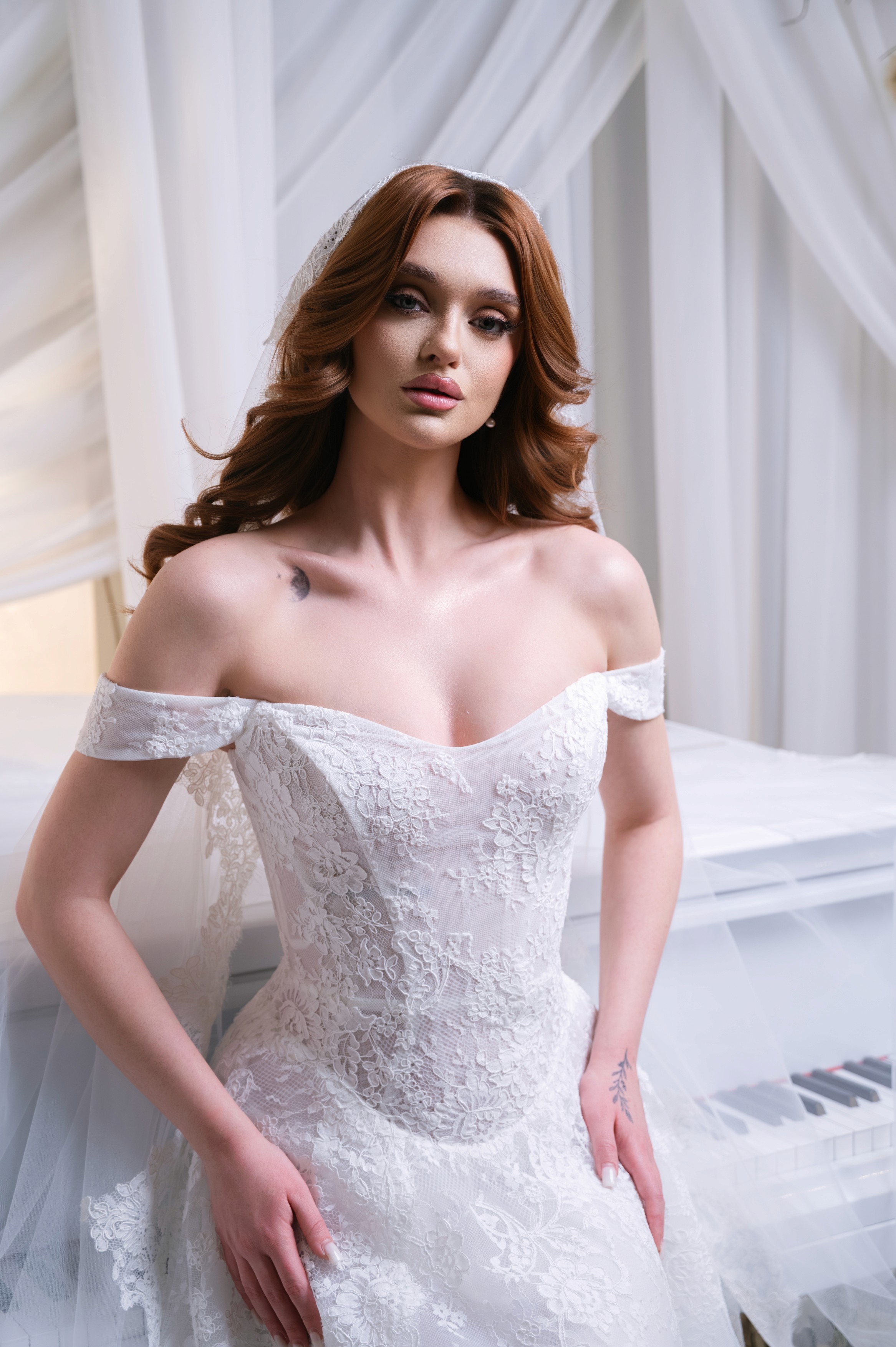 Prim-plan cu mireasă și pian alb într-un decor luminos, ședință foto bridal în București