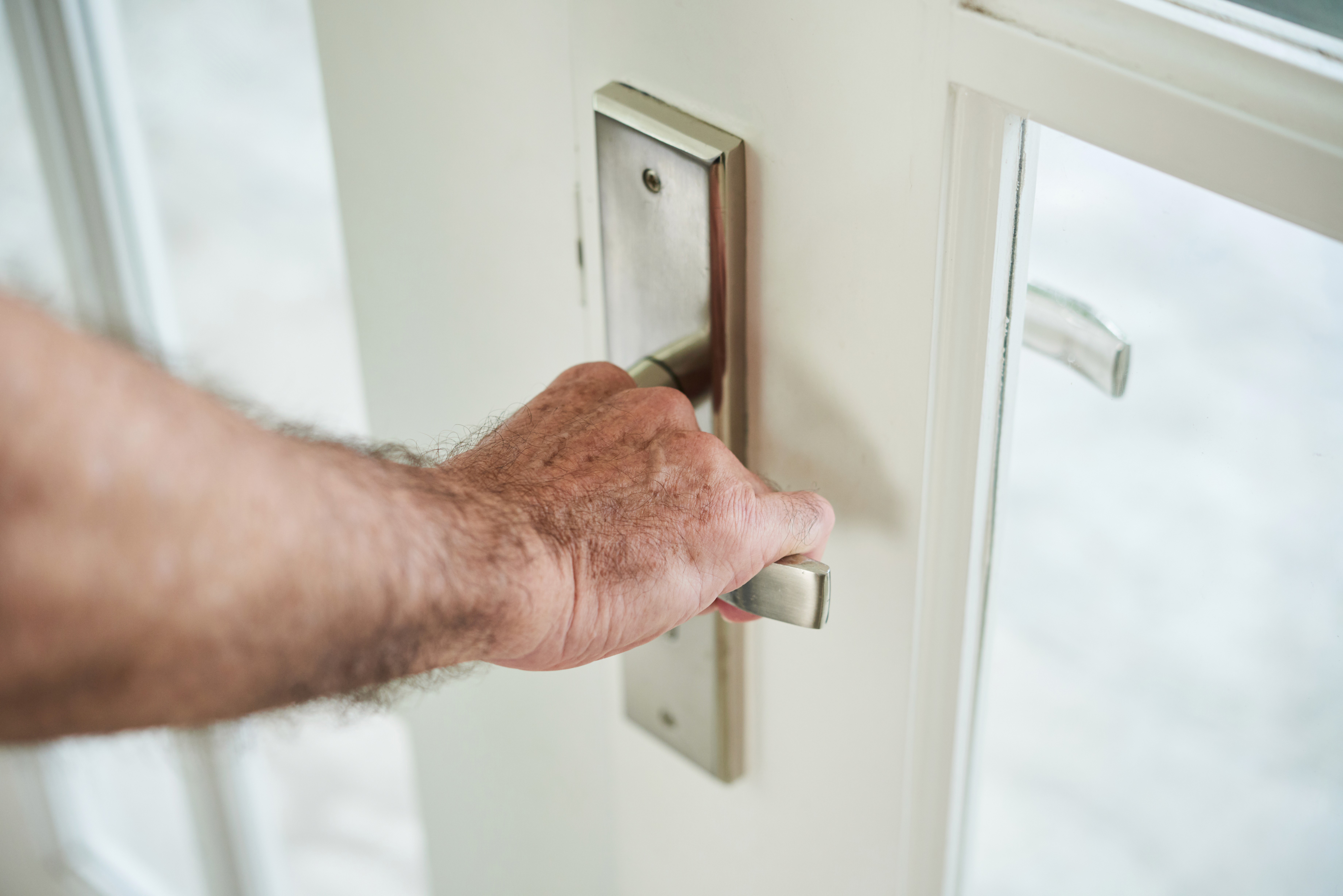 A hand reaching to a door handle