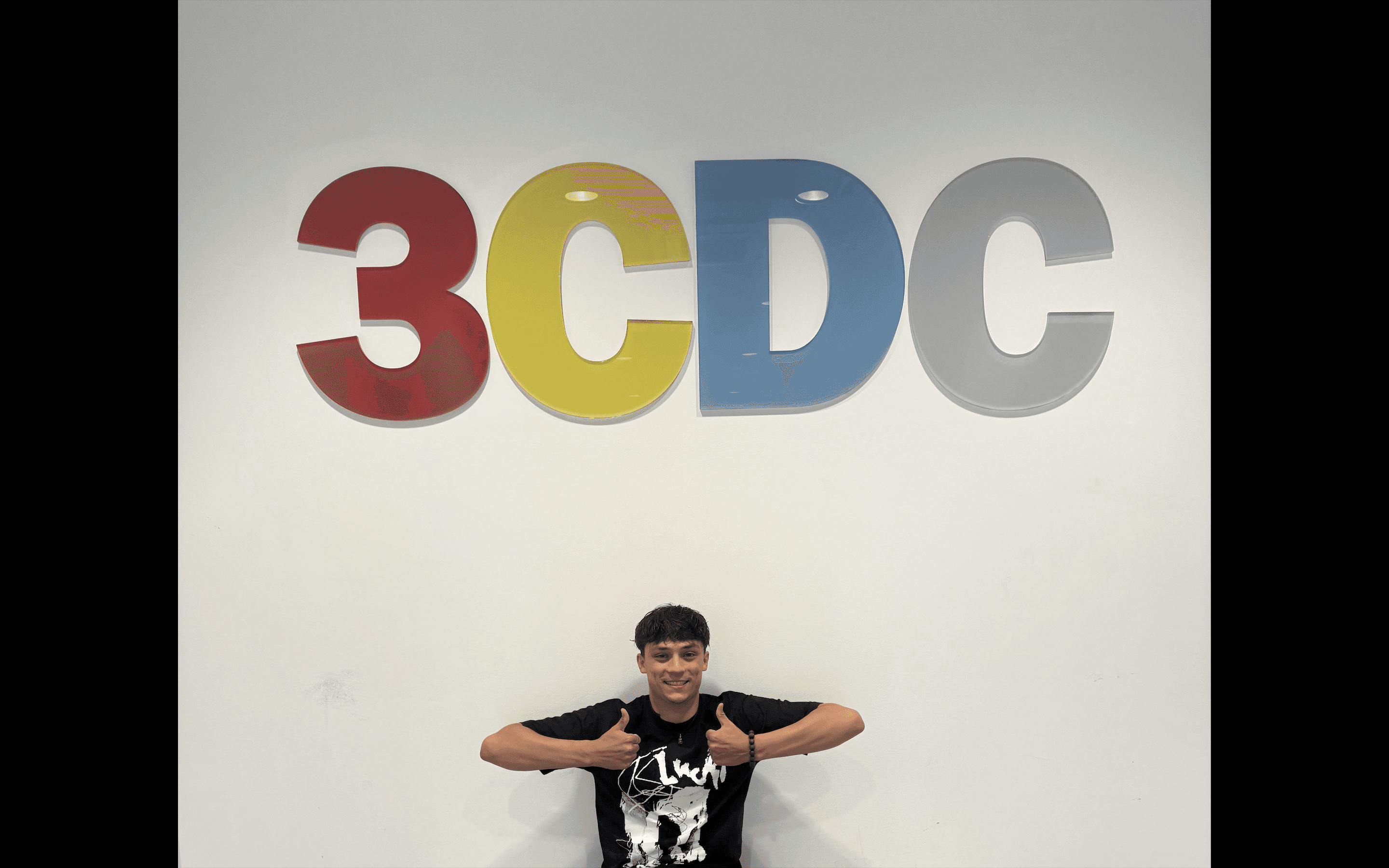 A thoughtful young person with dark hair gazes to the side, captured in soft black and white lighting.