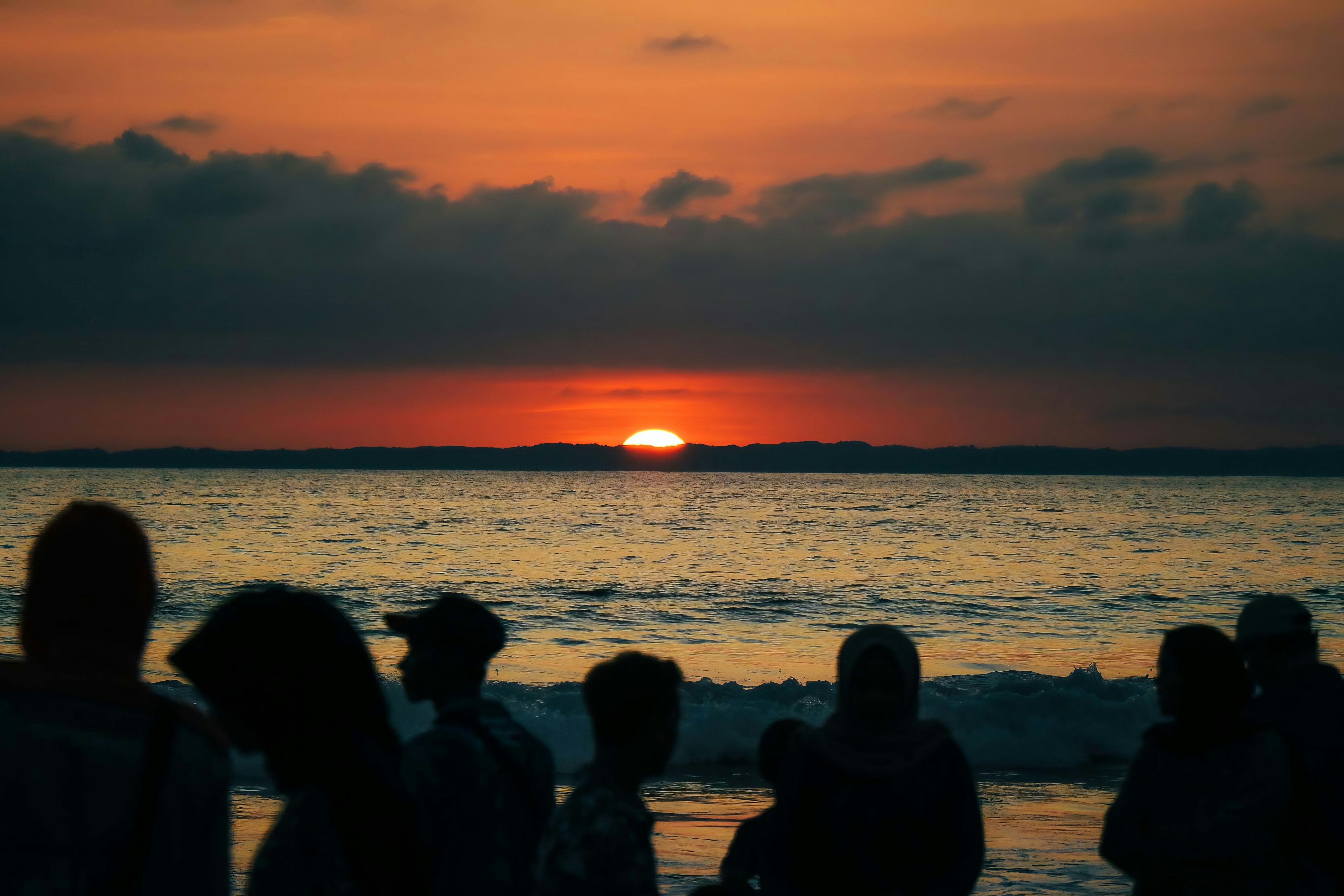 a group of people standing on top of a beach