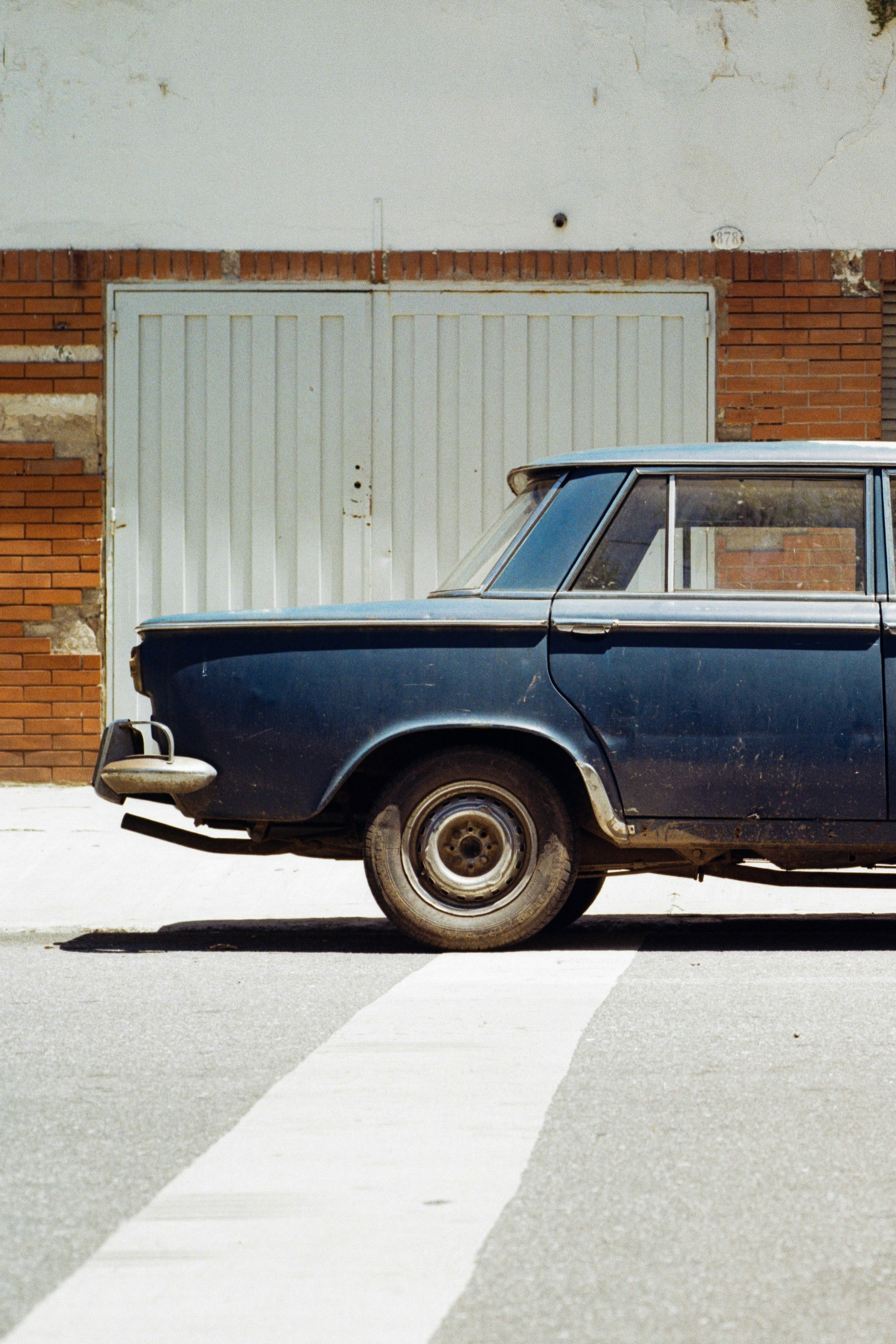 Side view of a vintage blue car parked.