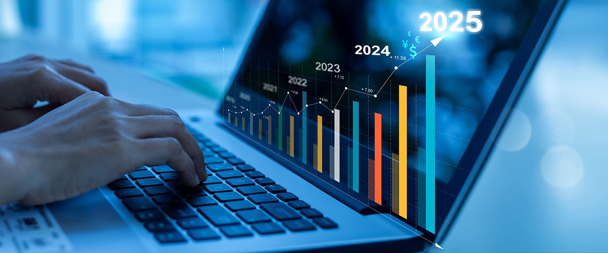 A close-up of a laptop screen displaying data analytics graphs and charts in a blue-toned environment.