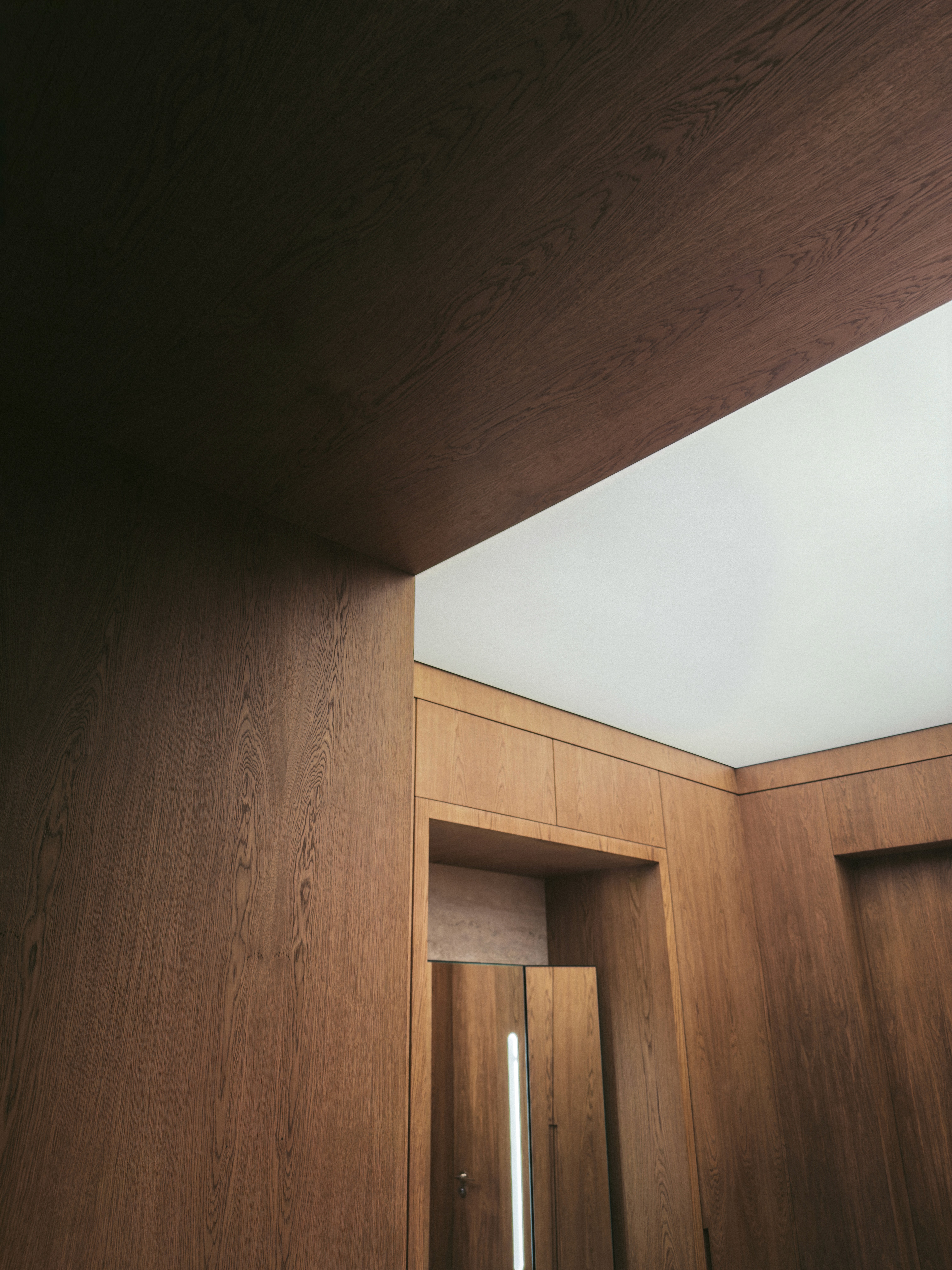 Architectural ceiling detail with warm timber cladding and ceiling lightbox