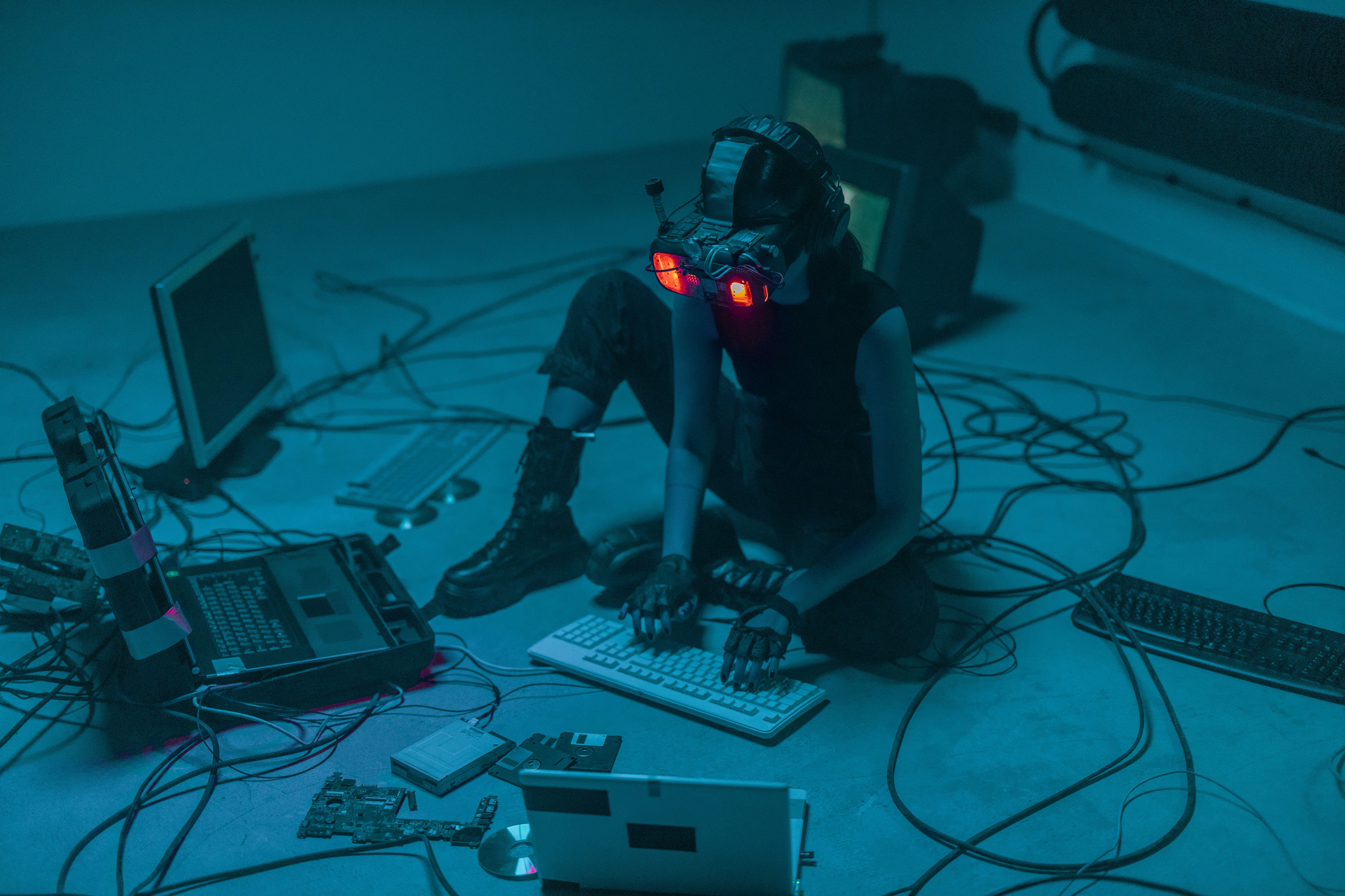A woman in VR gear surrounded by computers and cables, immersed in a virtual simulation.