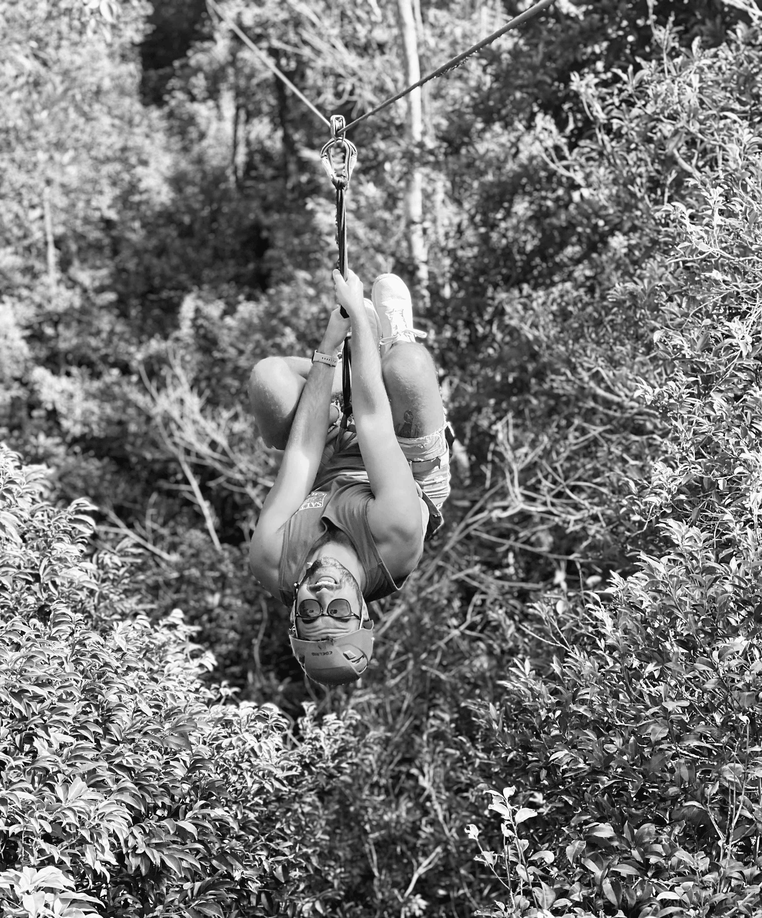 Four diverse professionals collaboratively working on a laptop, with one person pointing at the screen while others observe.